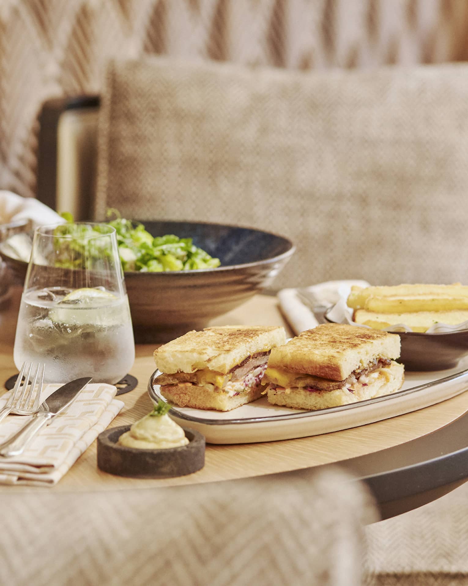 An assortment of pasta, salad and sandwiches on a small table.