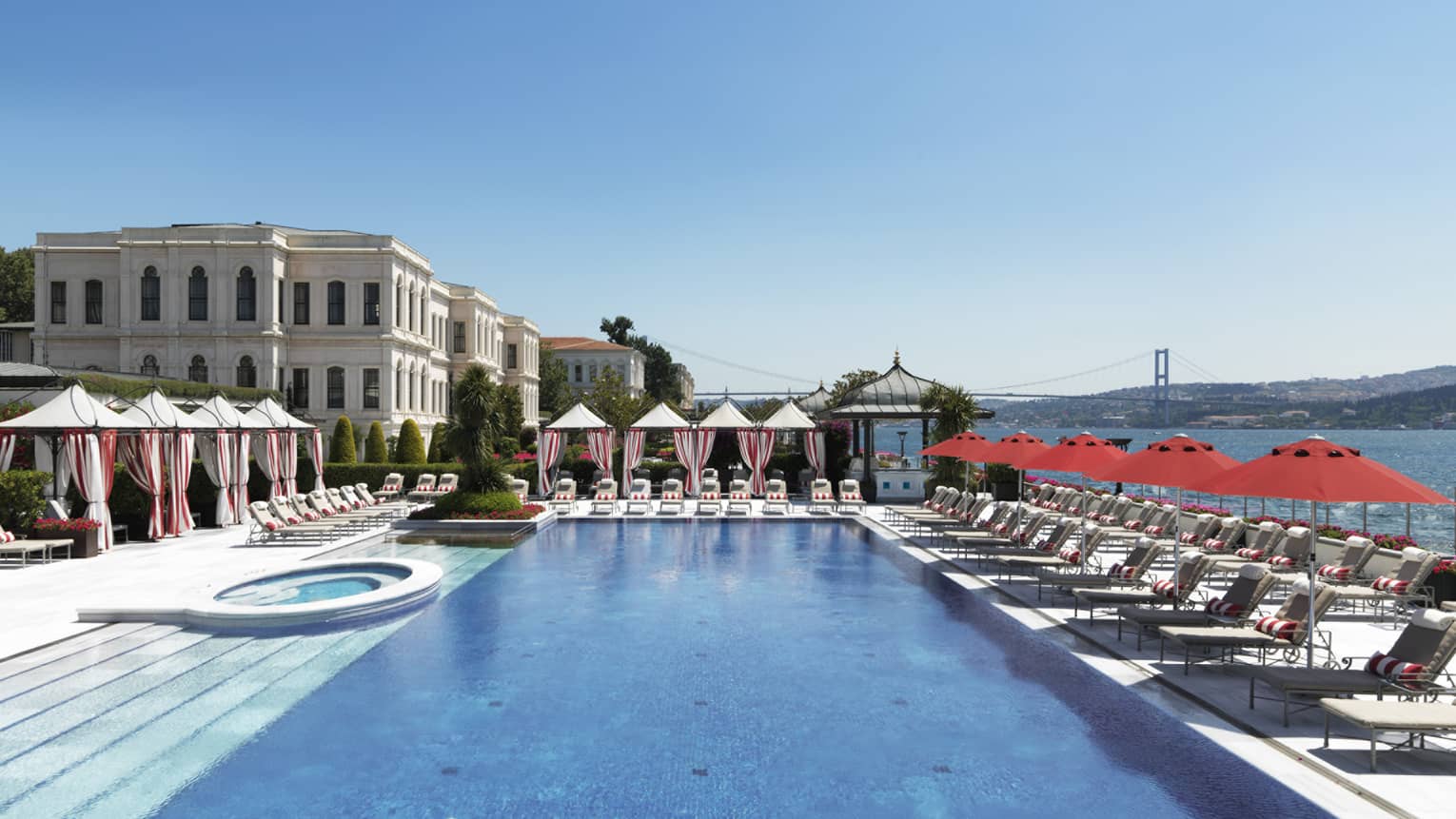 The Club large outdoor pool, sunny deck with rows of lounge chairs