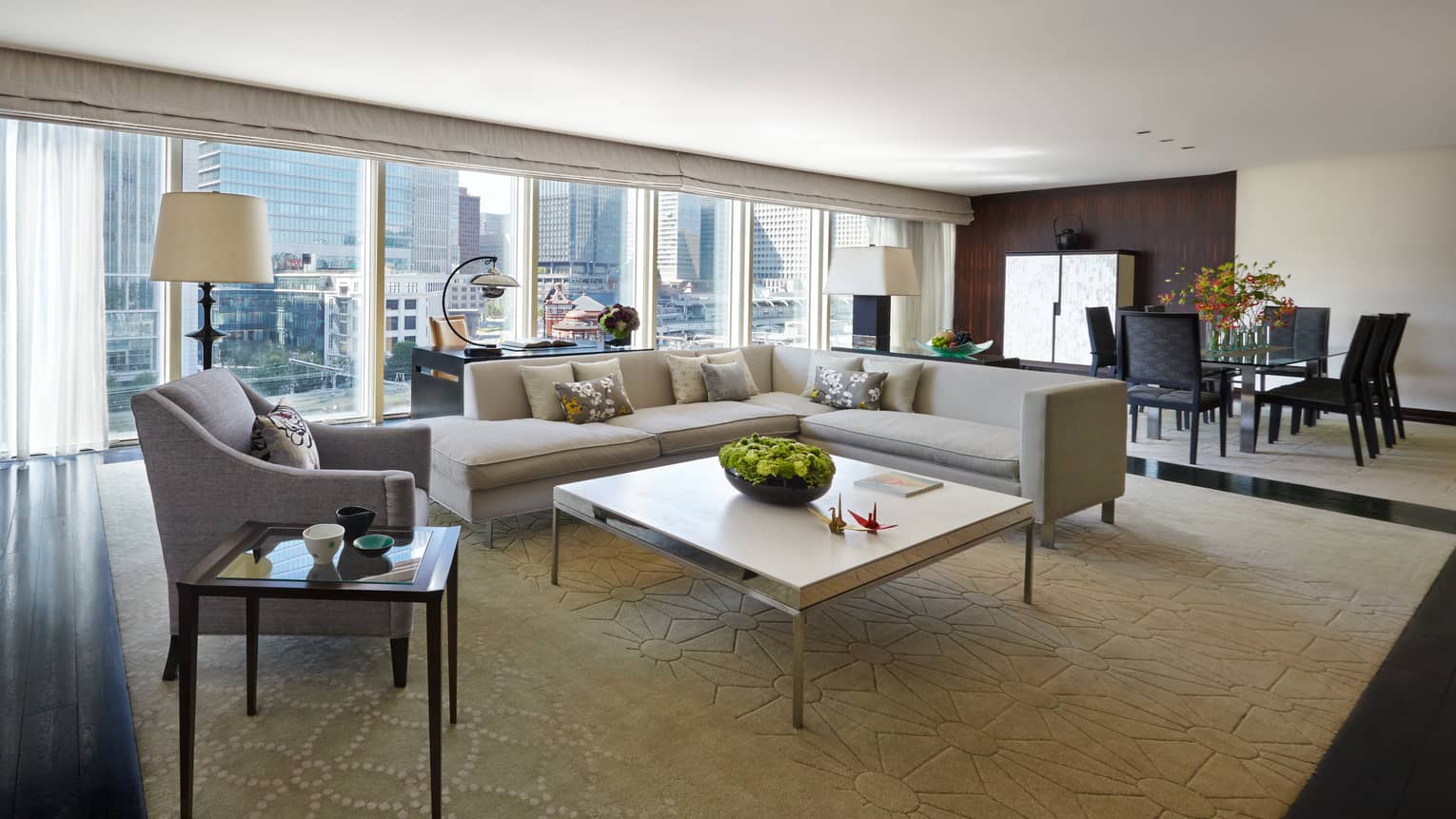 Chairman's Suite modern L-shaped grey sofa, armchair coffee table, wall of windows