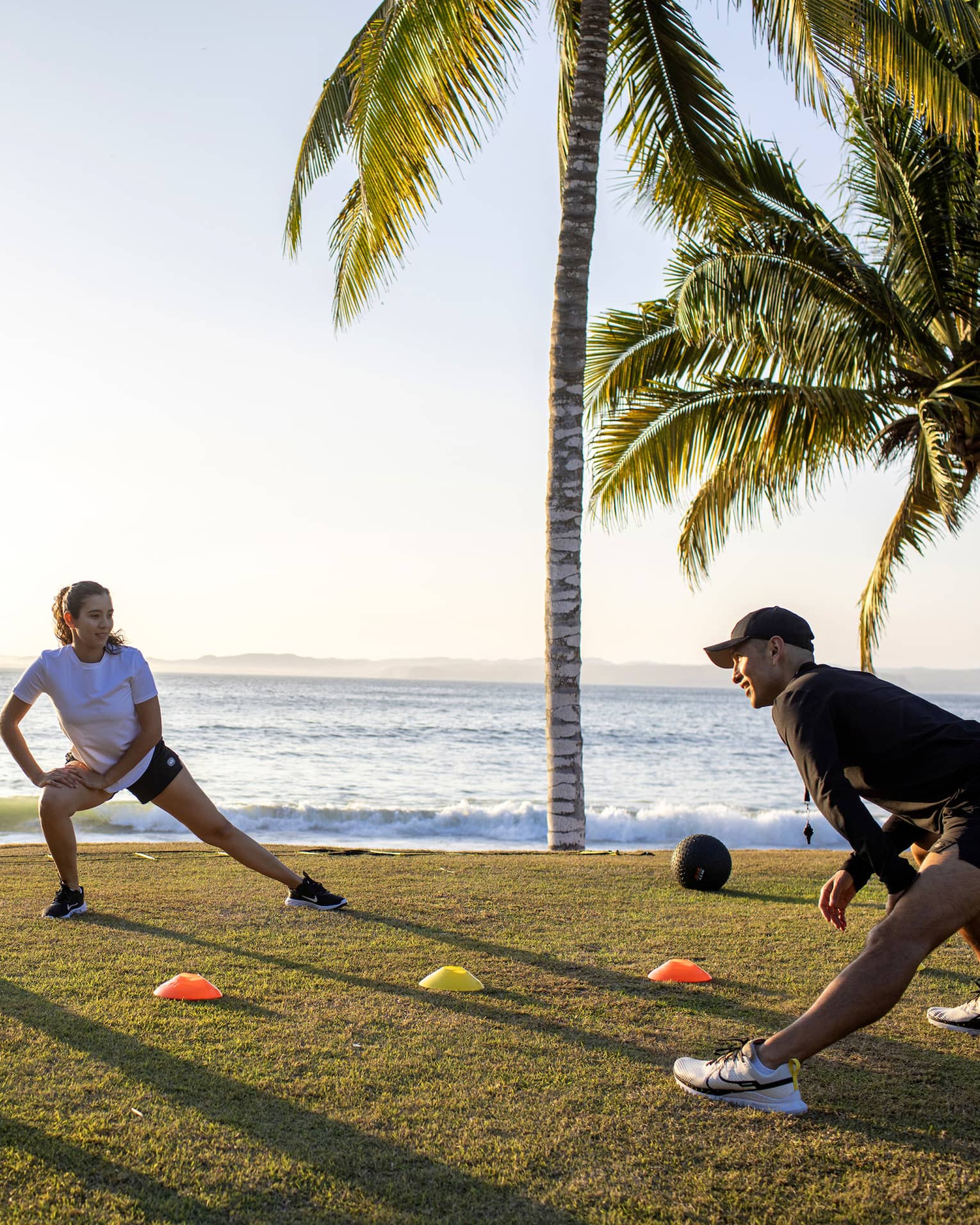 Four guests doing a fitness workout outside near the ocean