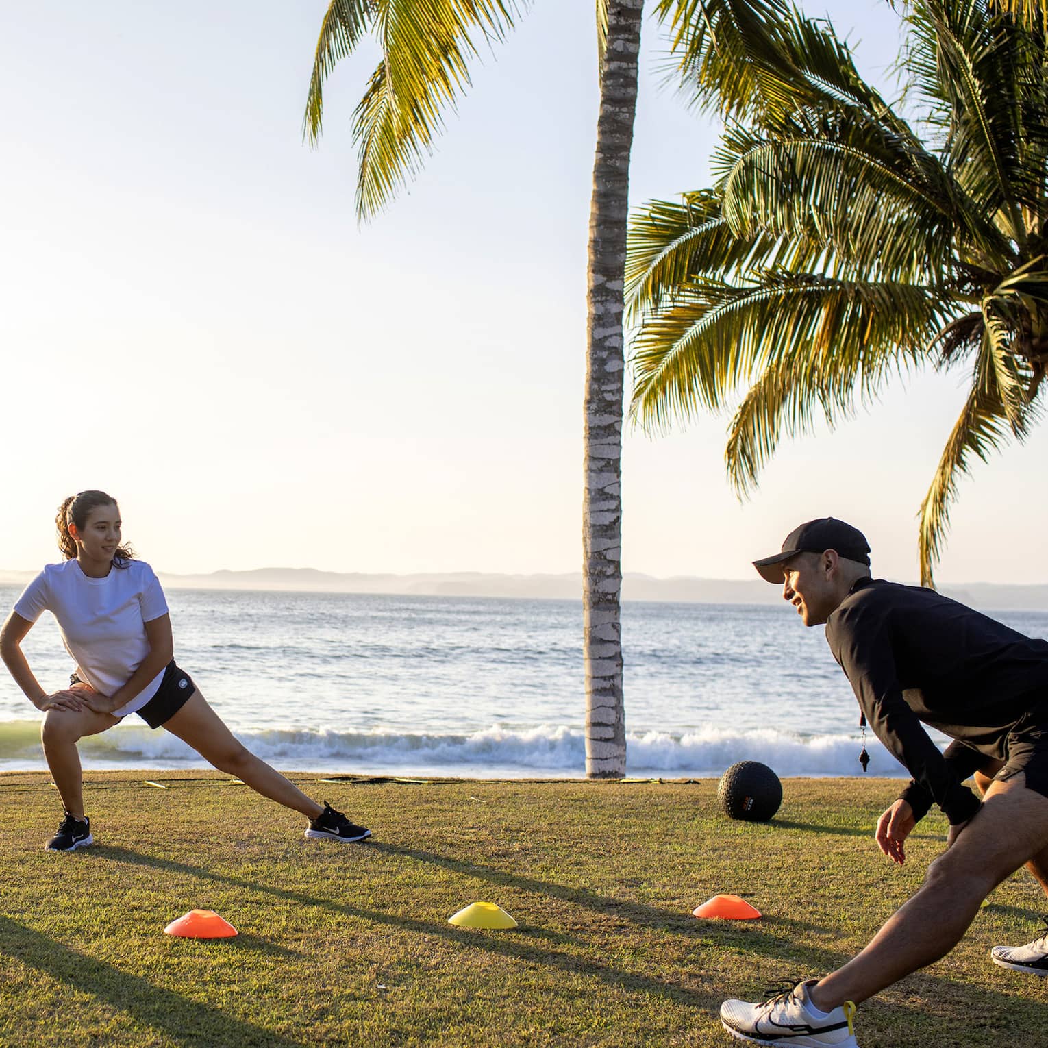 Four guests doing a fitness workout outside near the ocean