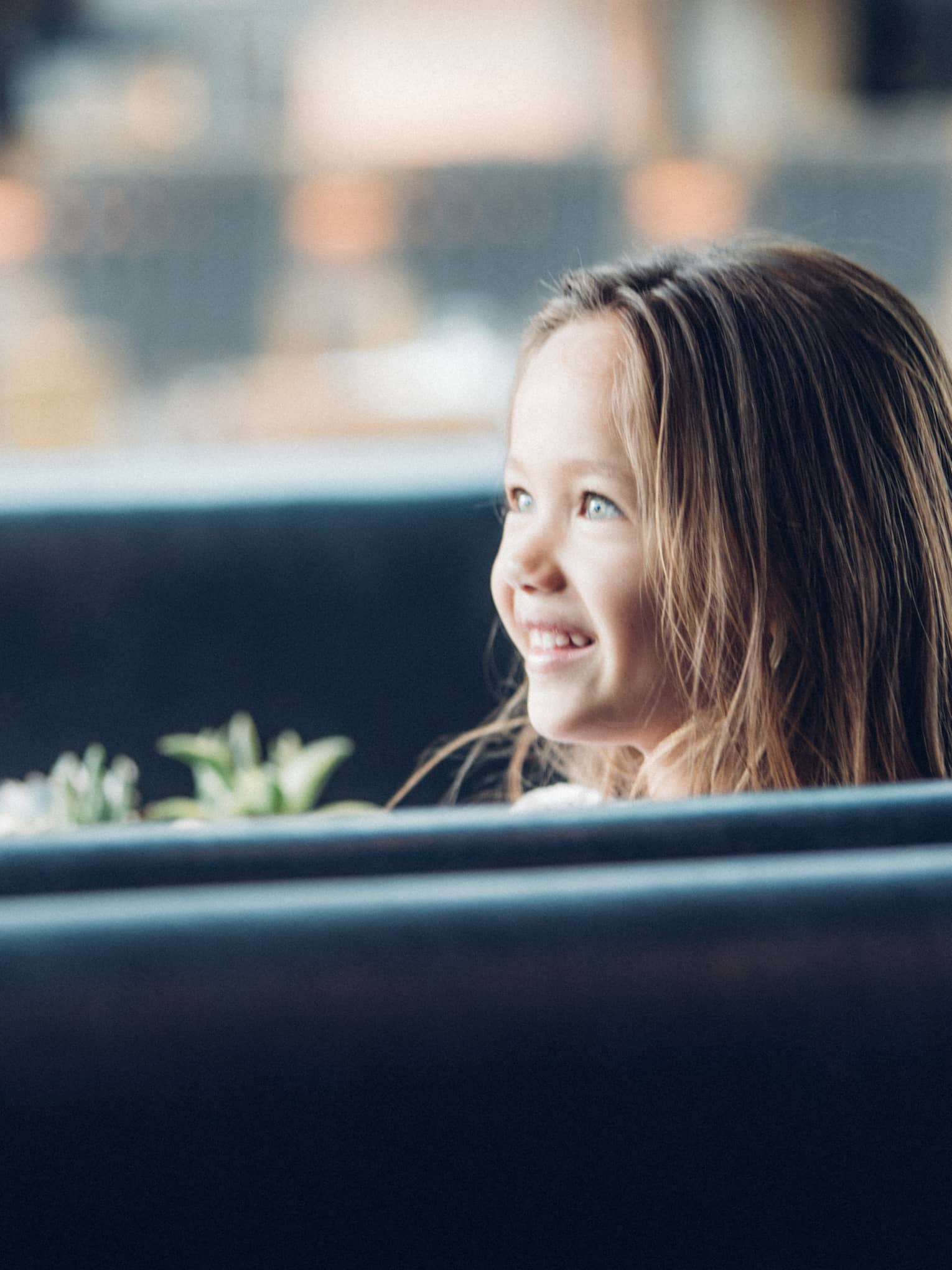 Woman in booth faces smiling, wide-eyed young girl