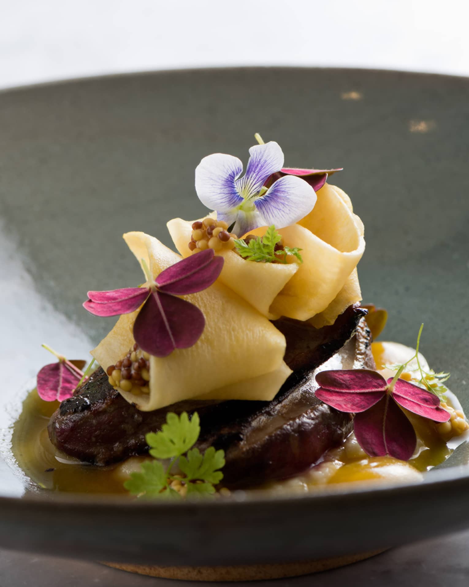 Elegantly presented meal in large bowl, garnished with fresh flowers 