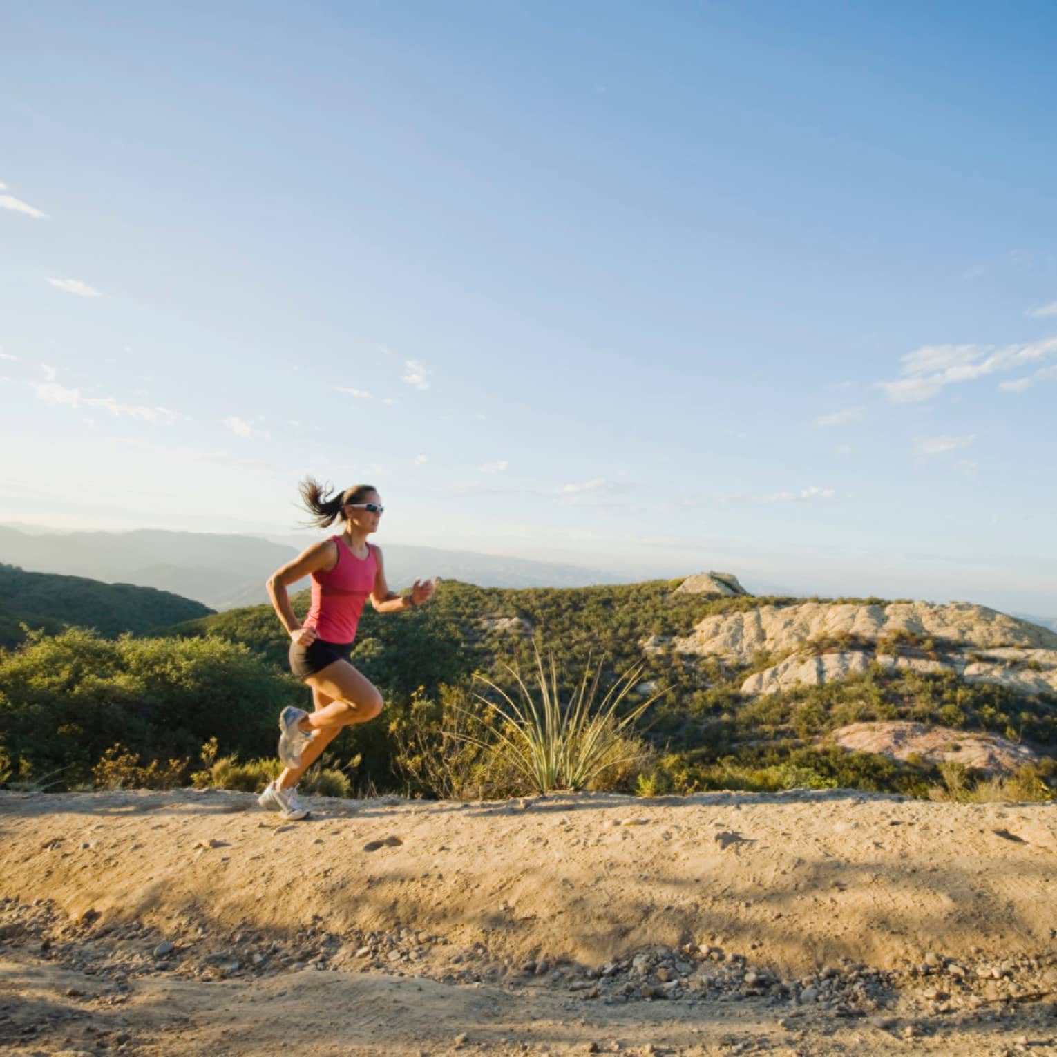 Woman jogs along sandy hill in Conejo Valley