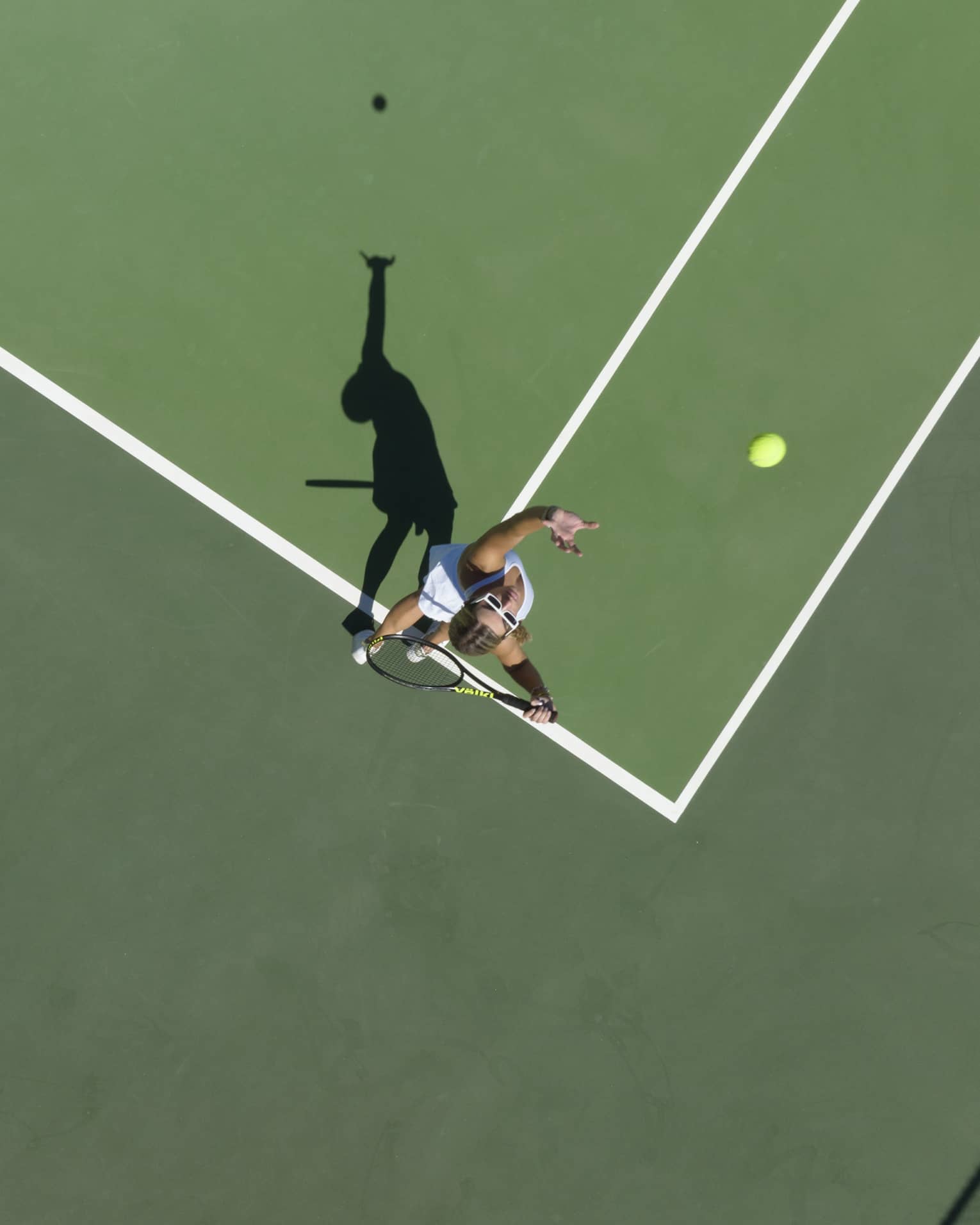 Aerial view of a tennis player mid serve