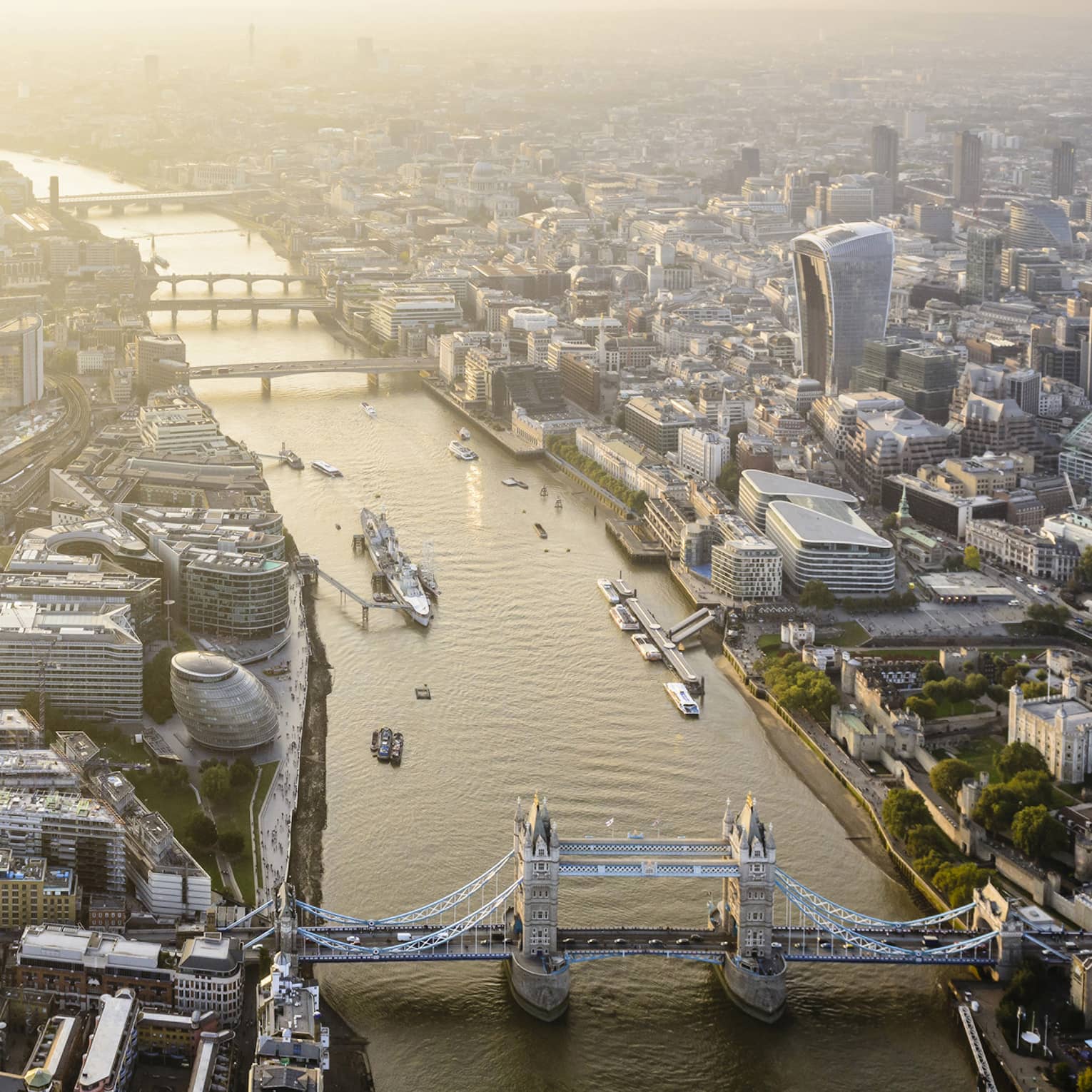 Aerial view of London city buildings along River Thames, London bridge in foreground 