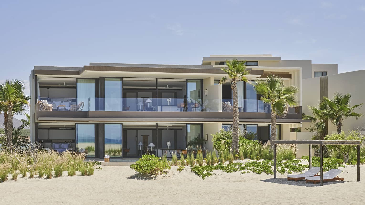 Two-story Sunrise Suite with Plunge Pool with palm trees, wraparound deck and floor-to-ceiling windows