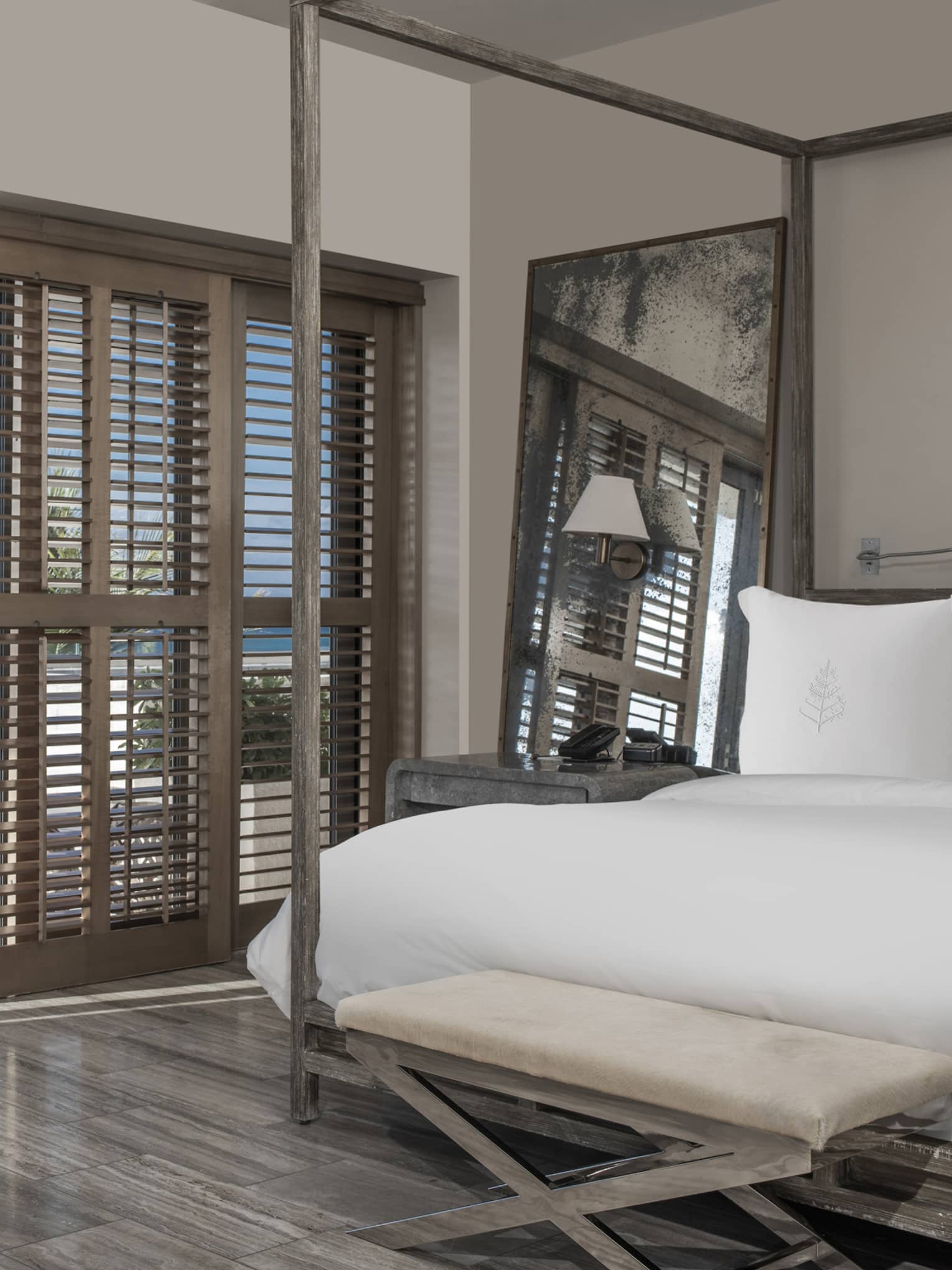 Bedroom with four-post bed, shutter sliding doors opening to sea-view terrace