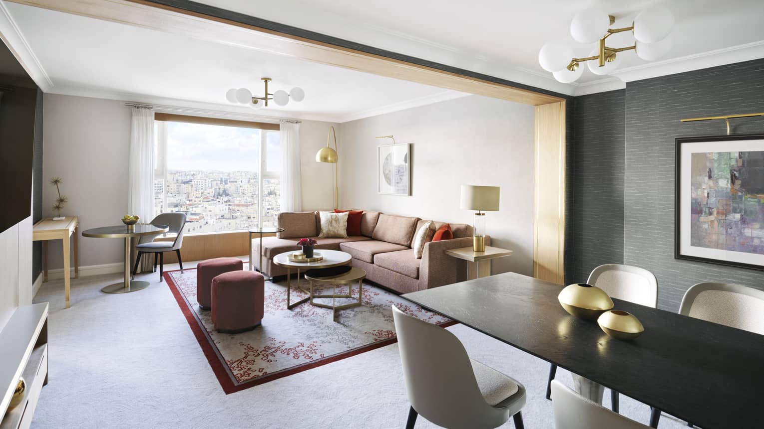 A spacious seating area with a black table surrounded by chairs and a loveseat all overlooking the city.