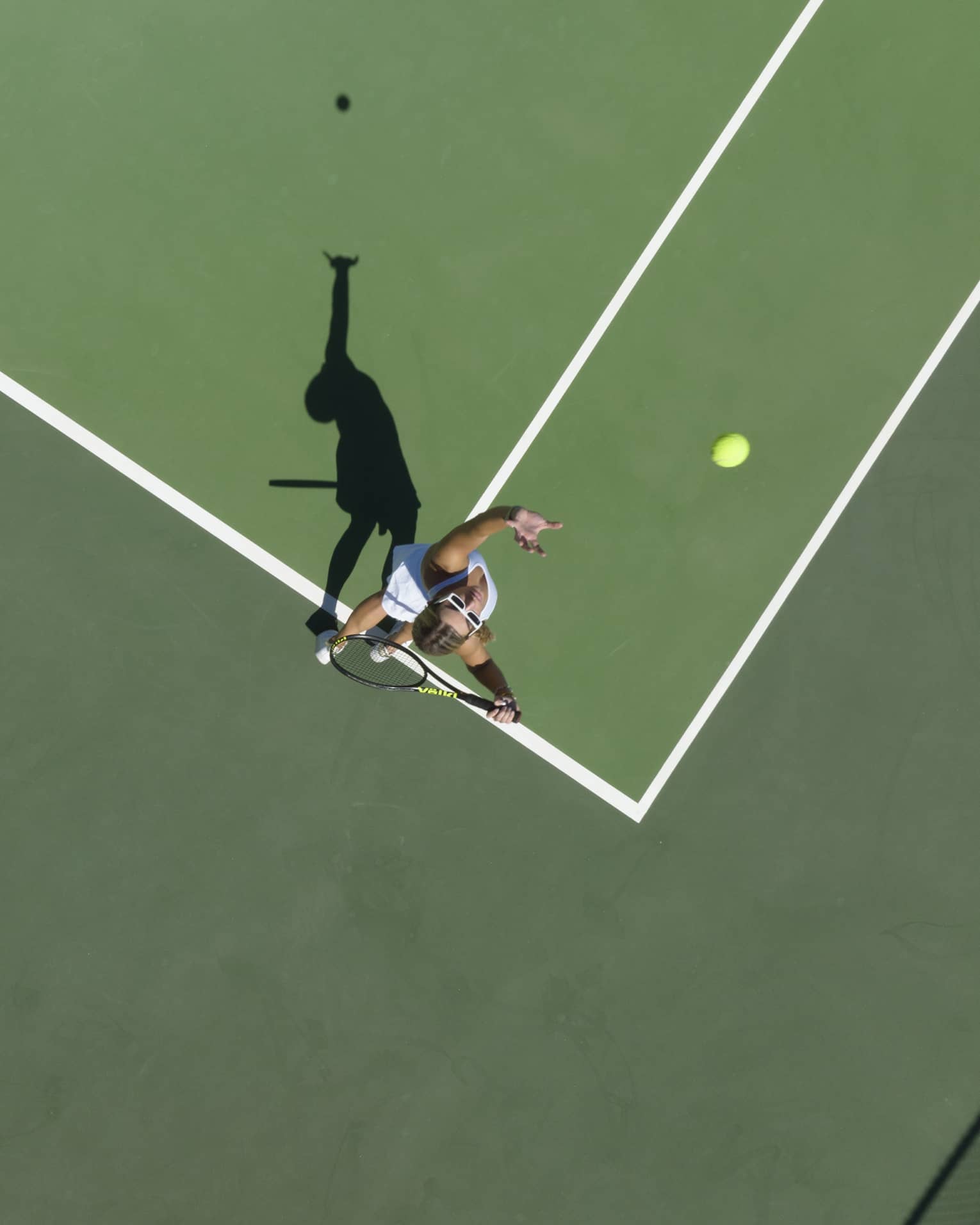 Aerial view of a tennis player mid serve