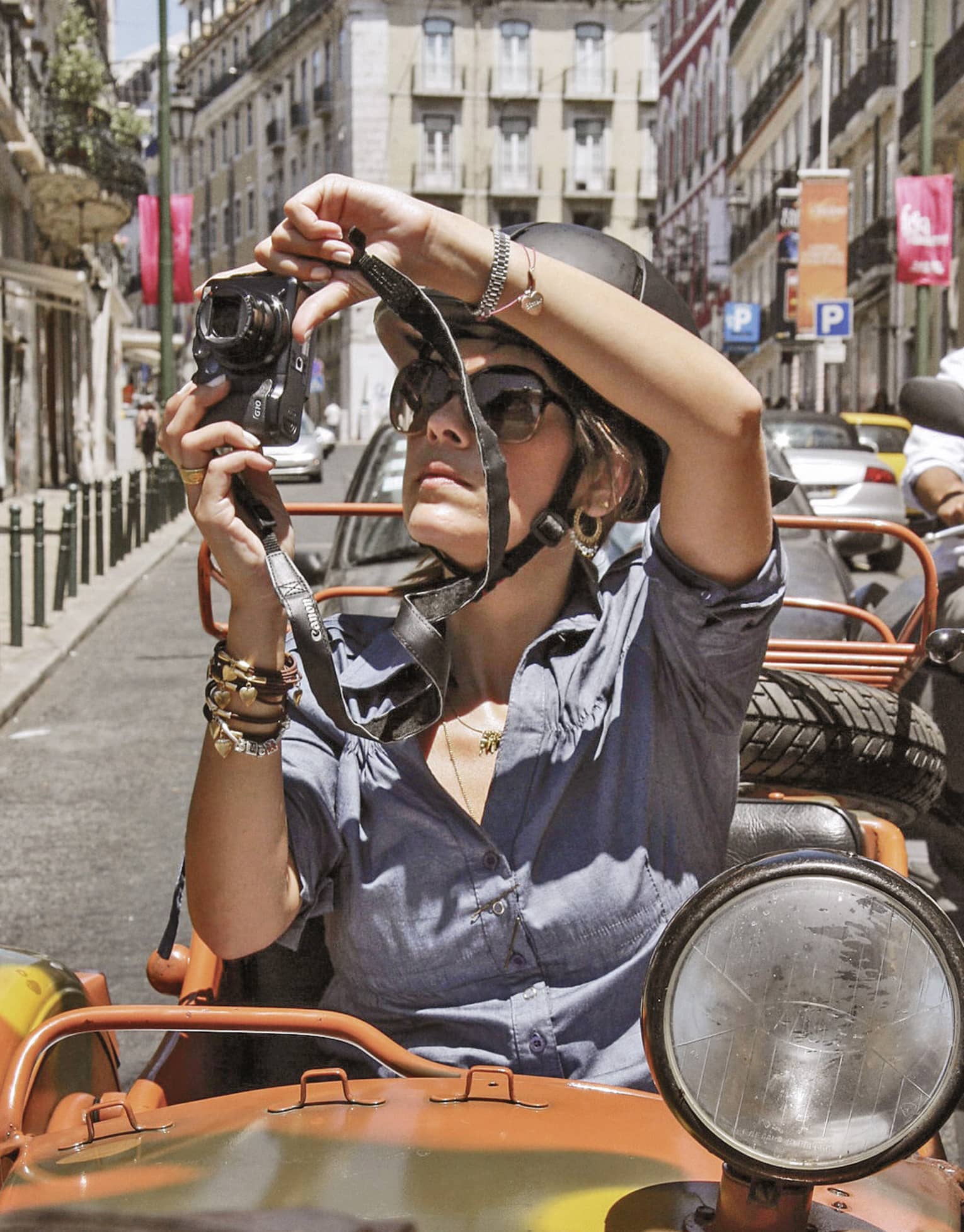 Woman sitting in Moto Side Car takes photos of streets