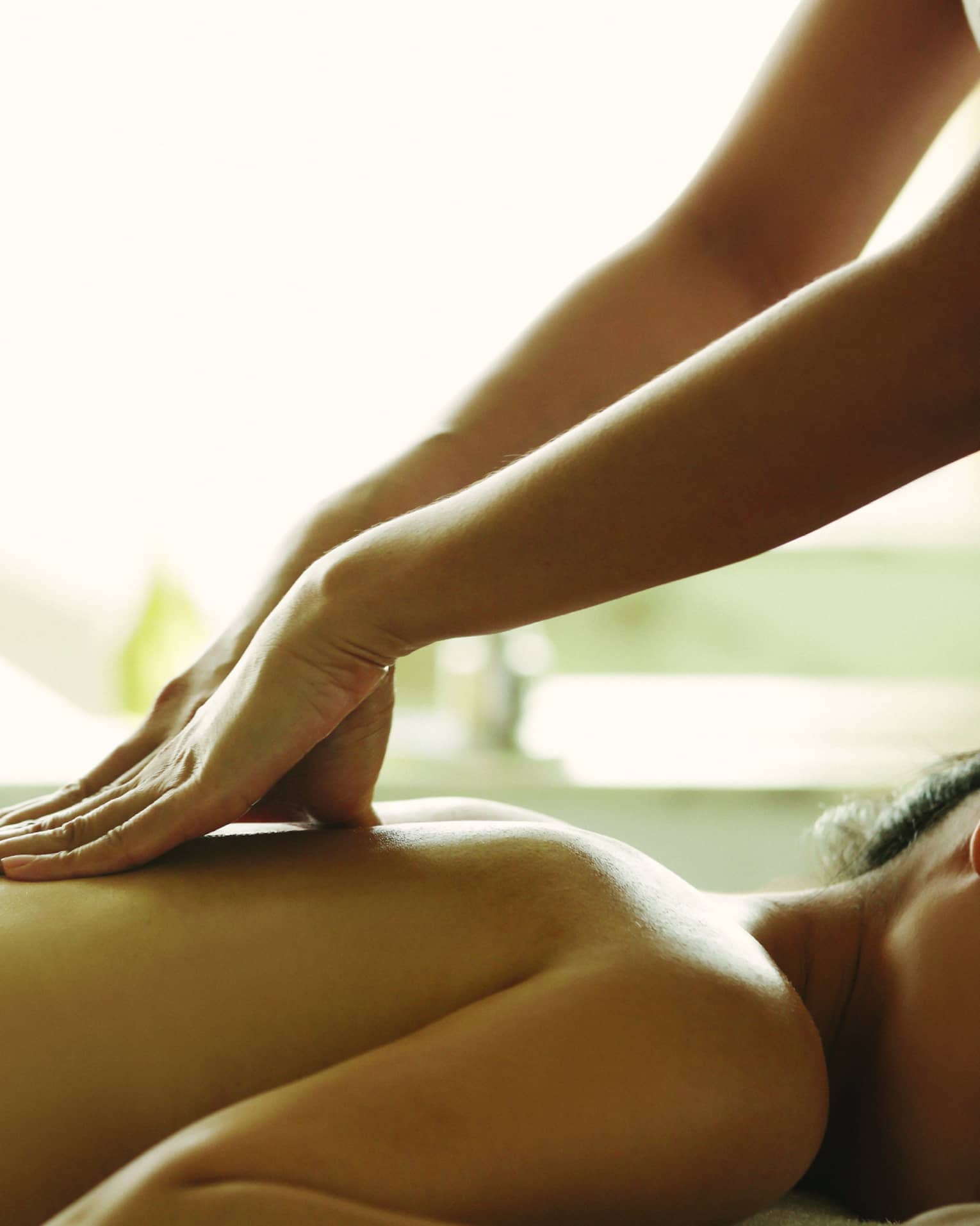 Close-up of a person receiving a relaxing back massage in a spa setting.