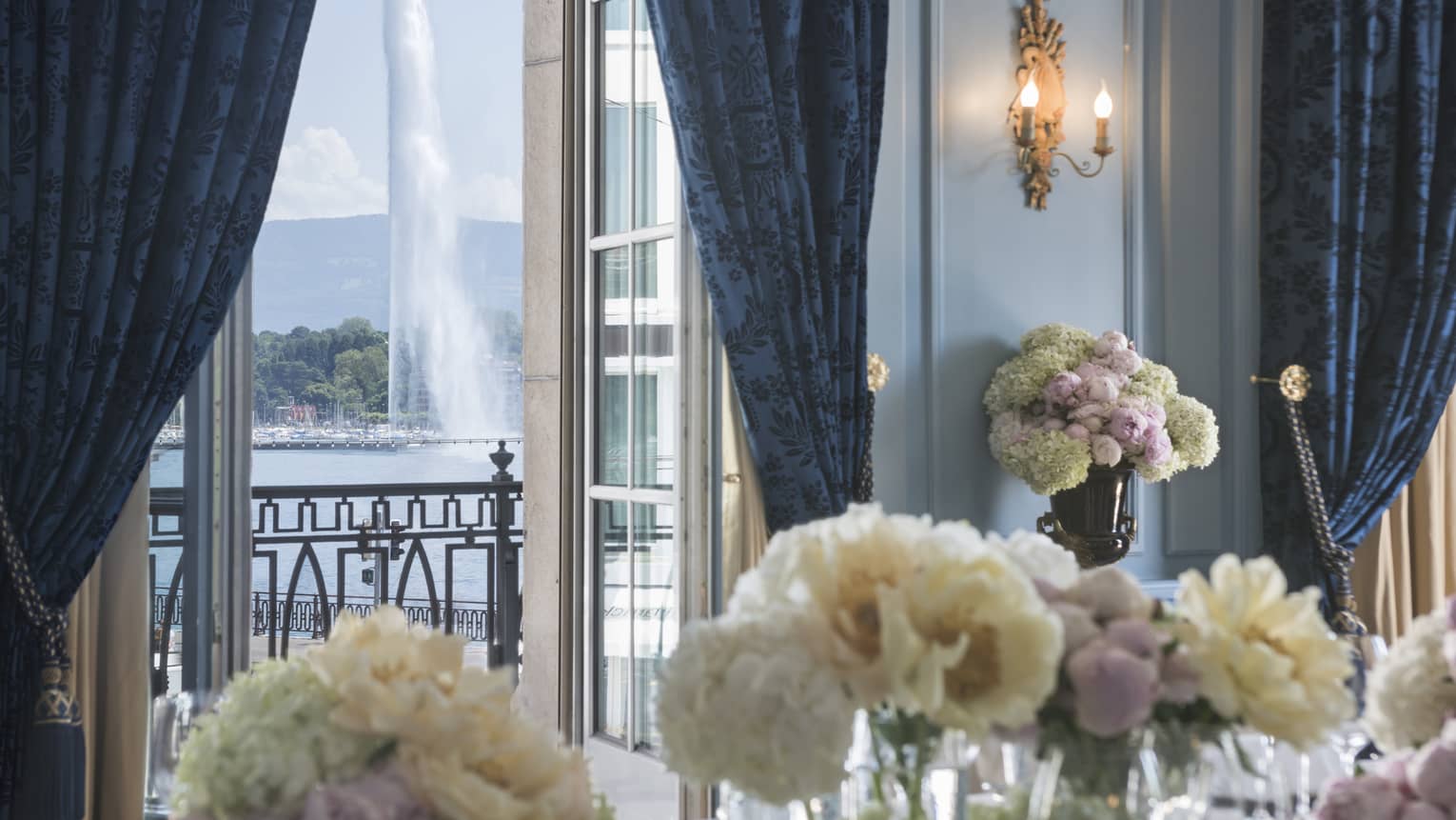 White flowers in Salon Petit Mont Blanc, open door to balcony with fountain view