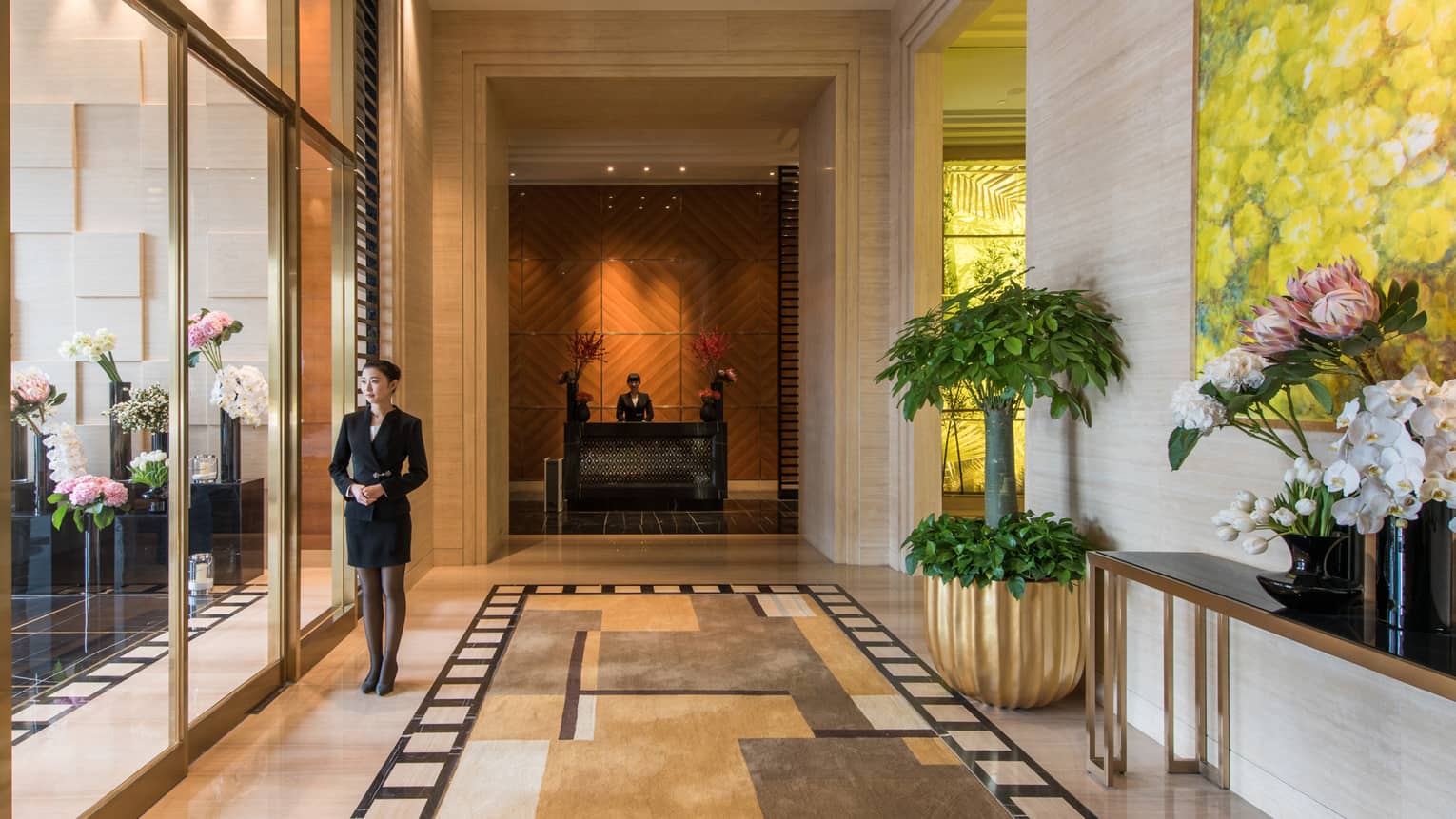 Concierge stands by sliding glass doors at residence entrance, lobby