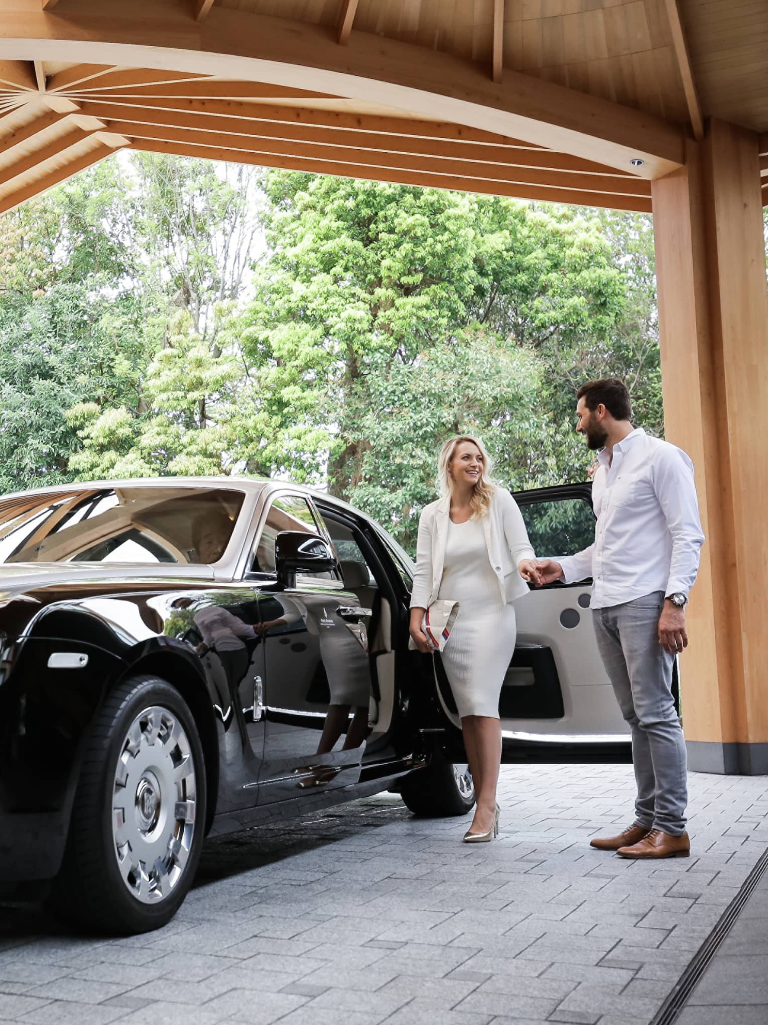 Couple exits black Bentley under awning at Four Seasons Hotel Kyoto