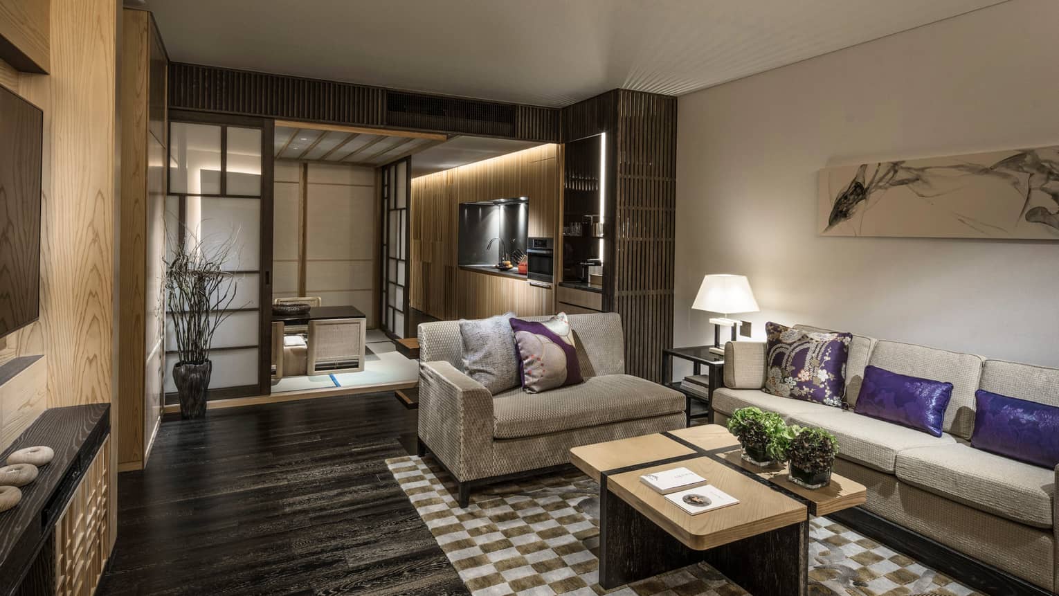 Dining residence with beige sofas, purple and beige cushions, kitchenette, coffee tables and traditional sliding doors leading to a tatami seating area