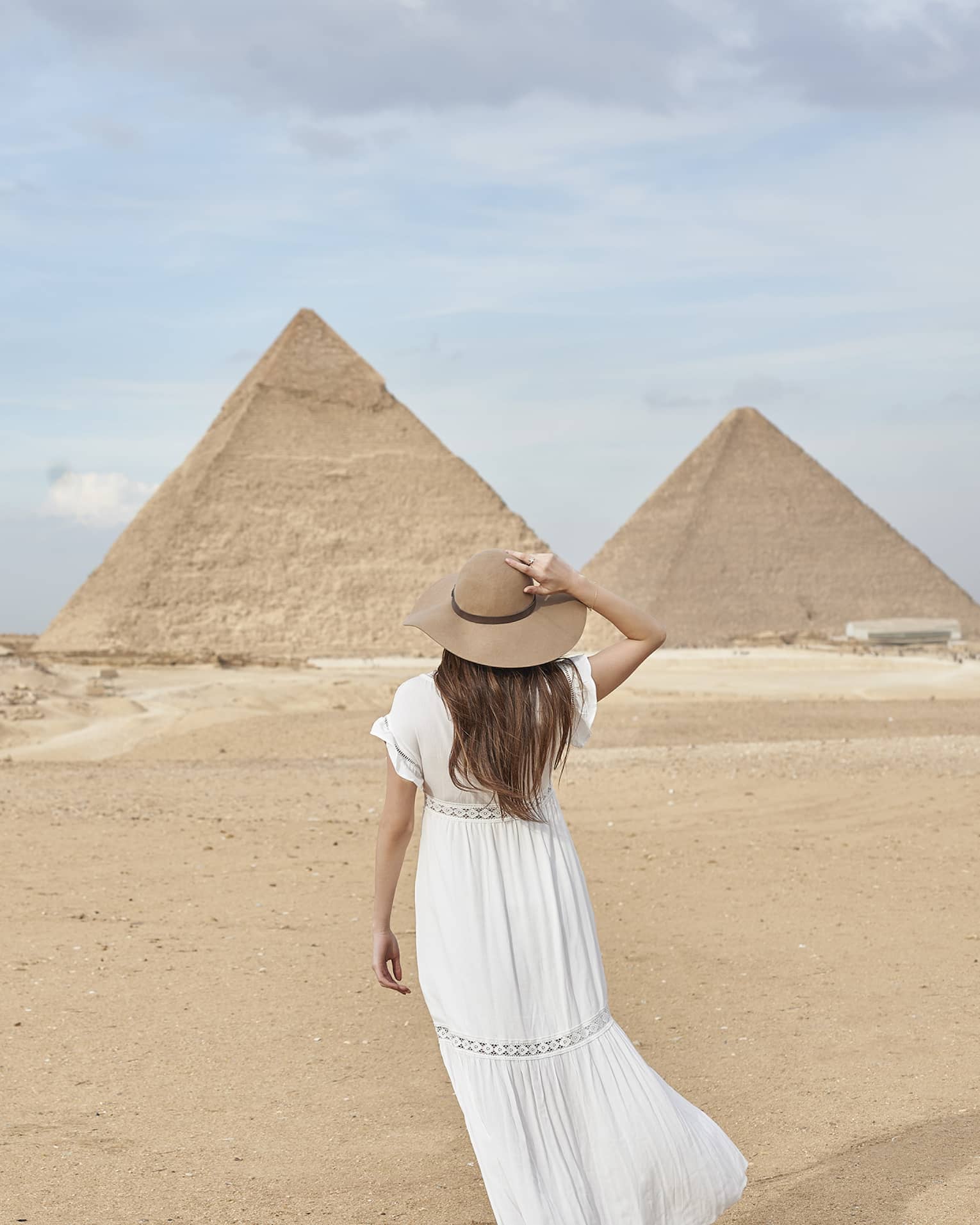 A guest wearing a linen dress observing the Great Pyramids