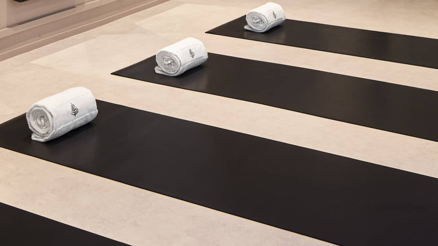 Yoga mats in a yoga studio with mirrors on the wall.