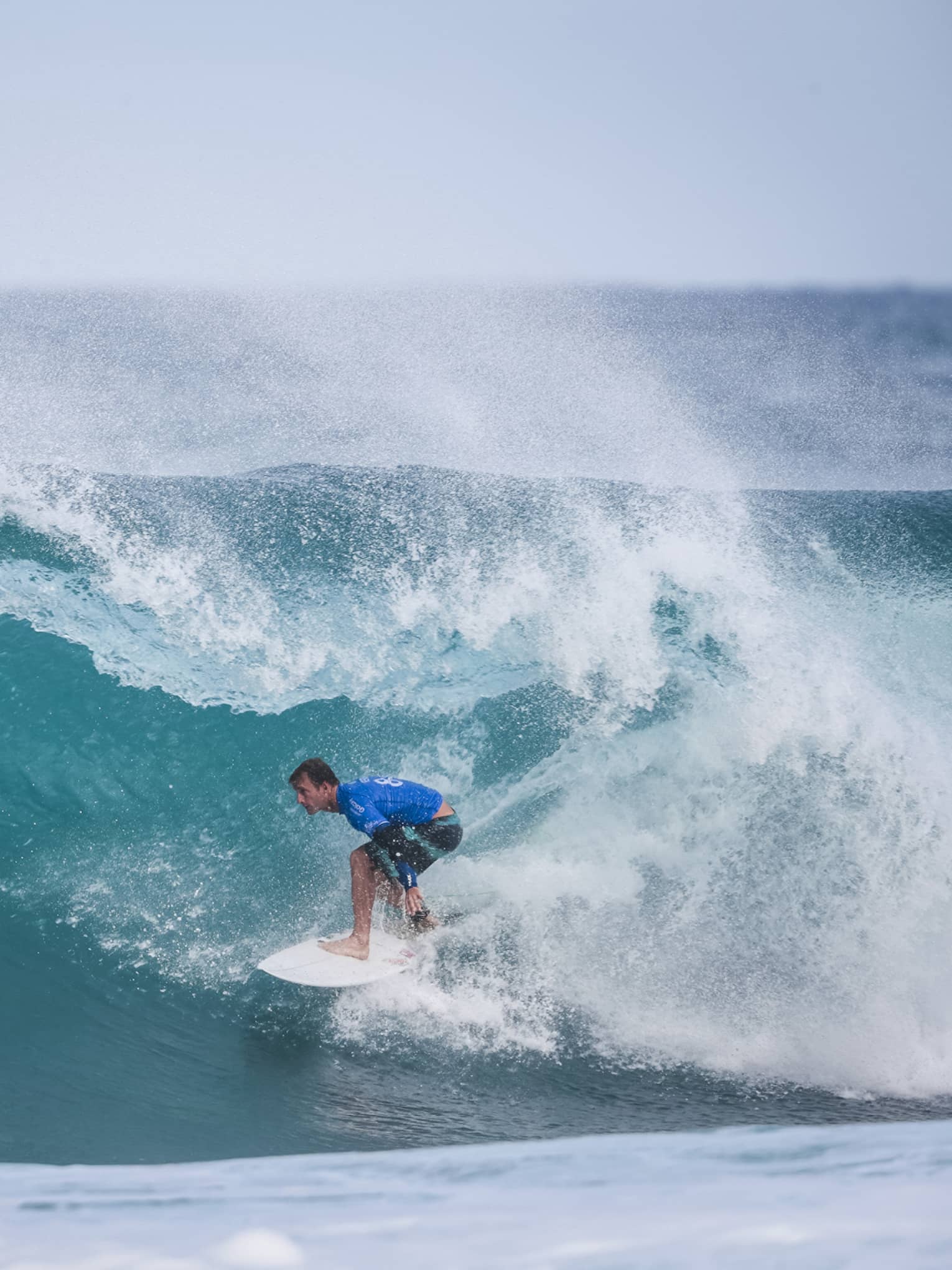 Josh Kerr riding a white board just before the wave breaks