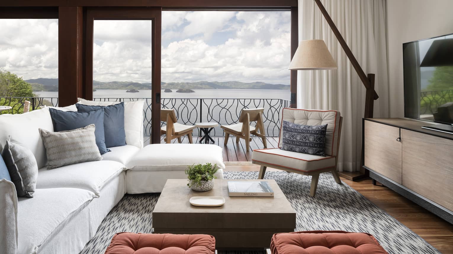Canopy Premier Plunge Pool Suite L-shaped white sofa in front of picture windows, balcony overlooking ocean