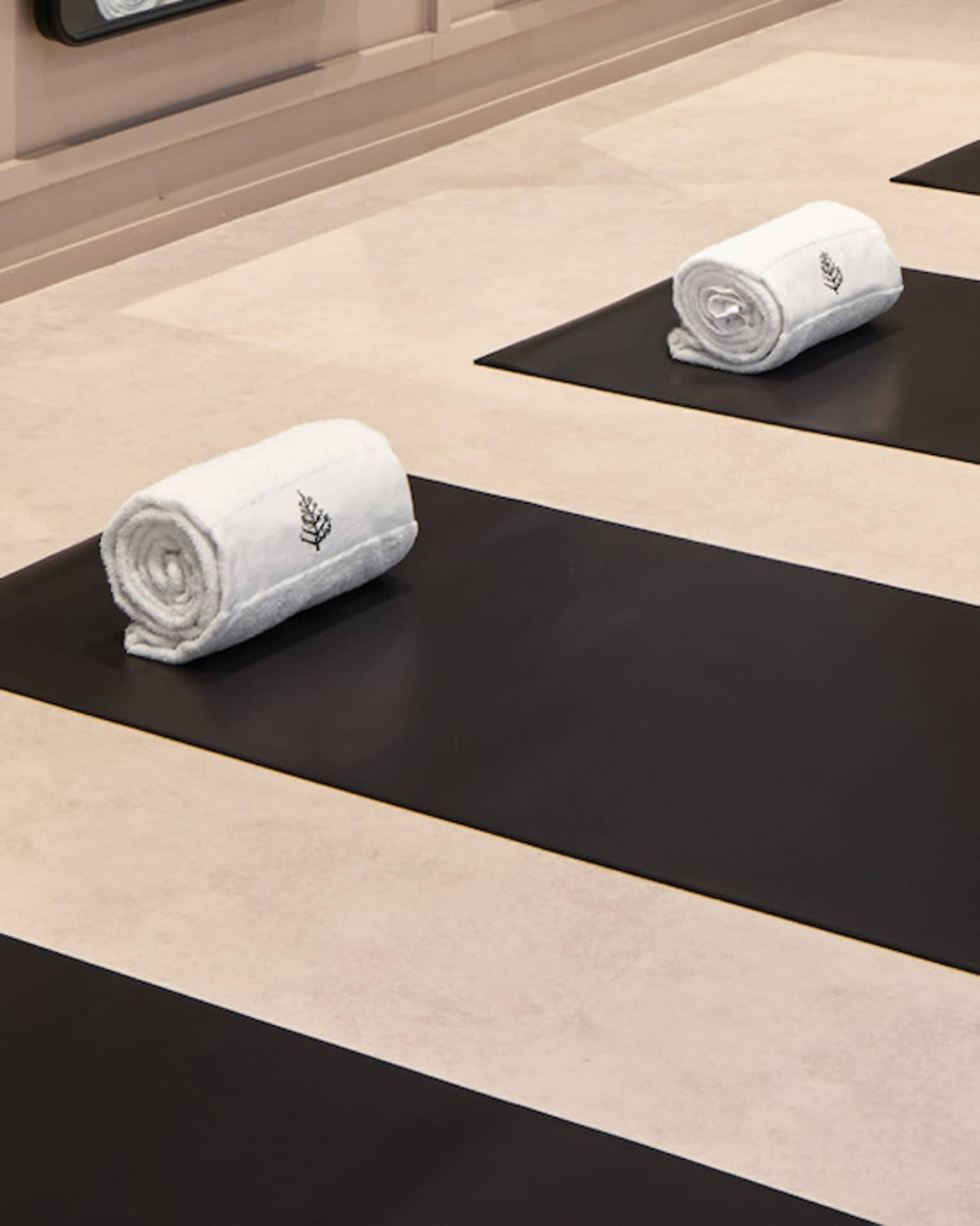 Yoga mats in a yoga studio with mirrors on the wall.