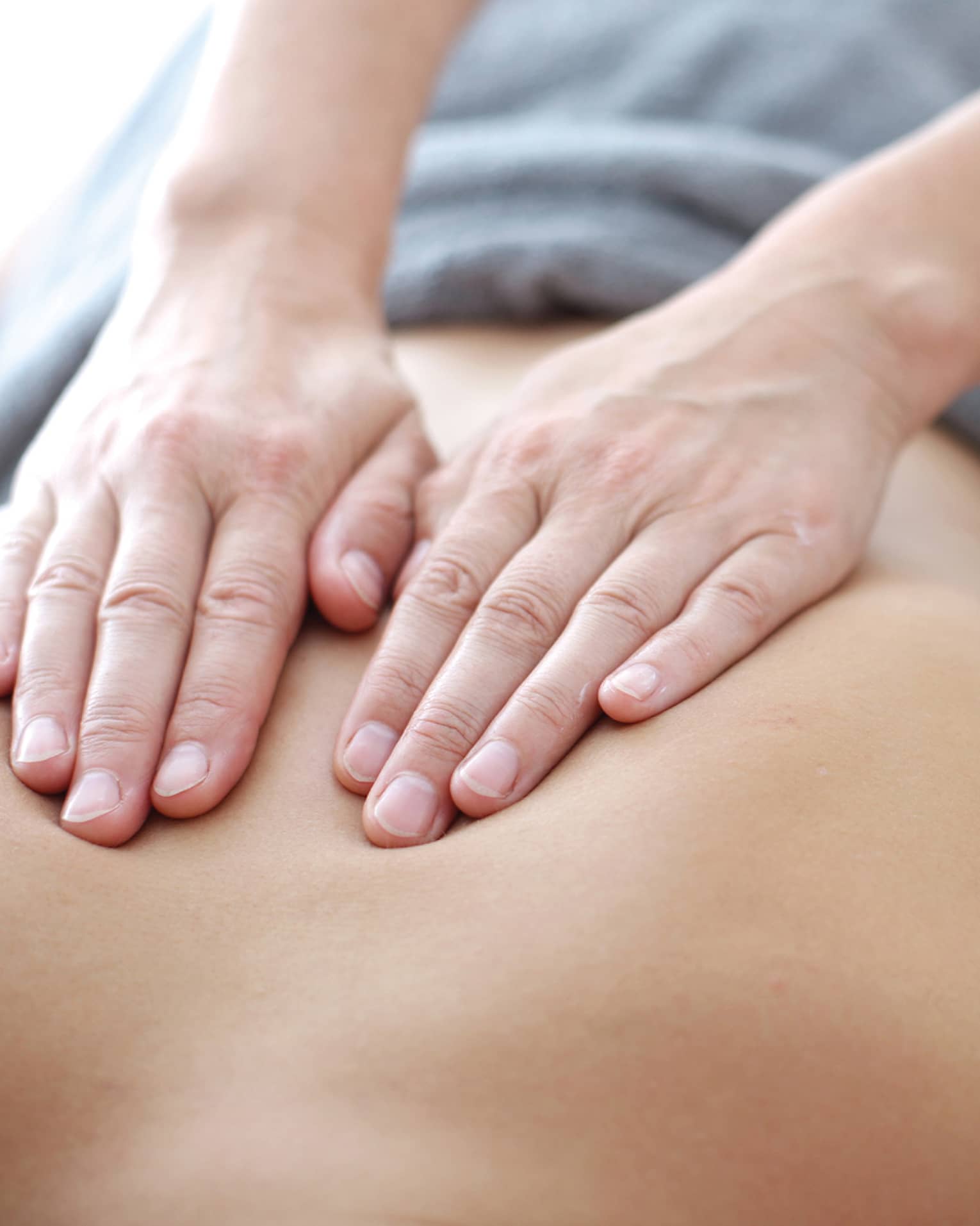 Hands massaging bare shoulders, back