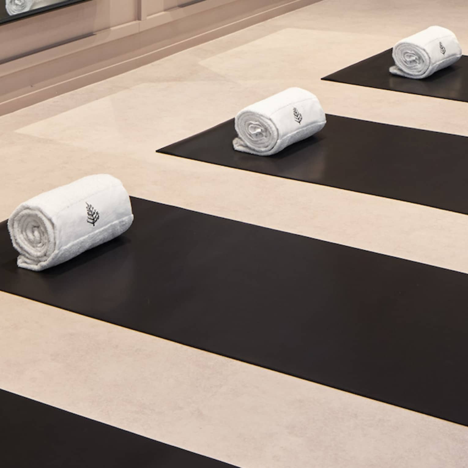 Yoga mats in a yoga studio with mirrors on the wall.