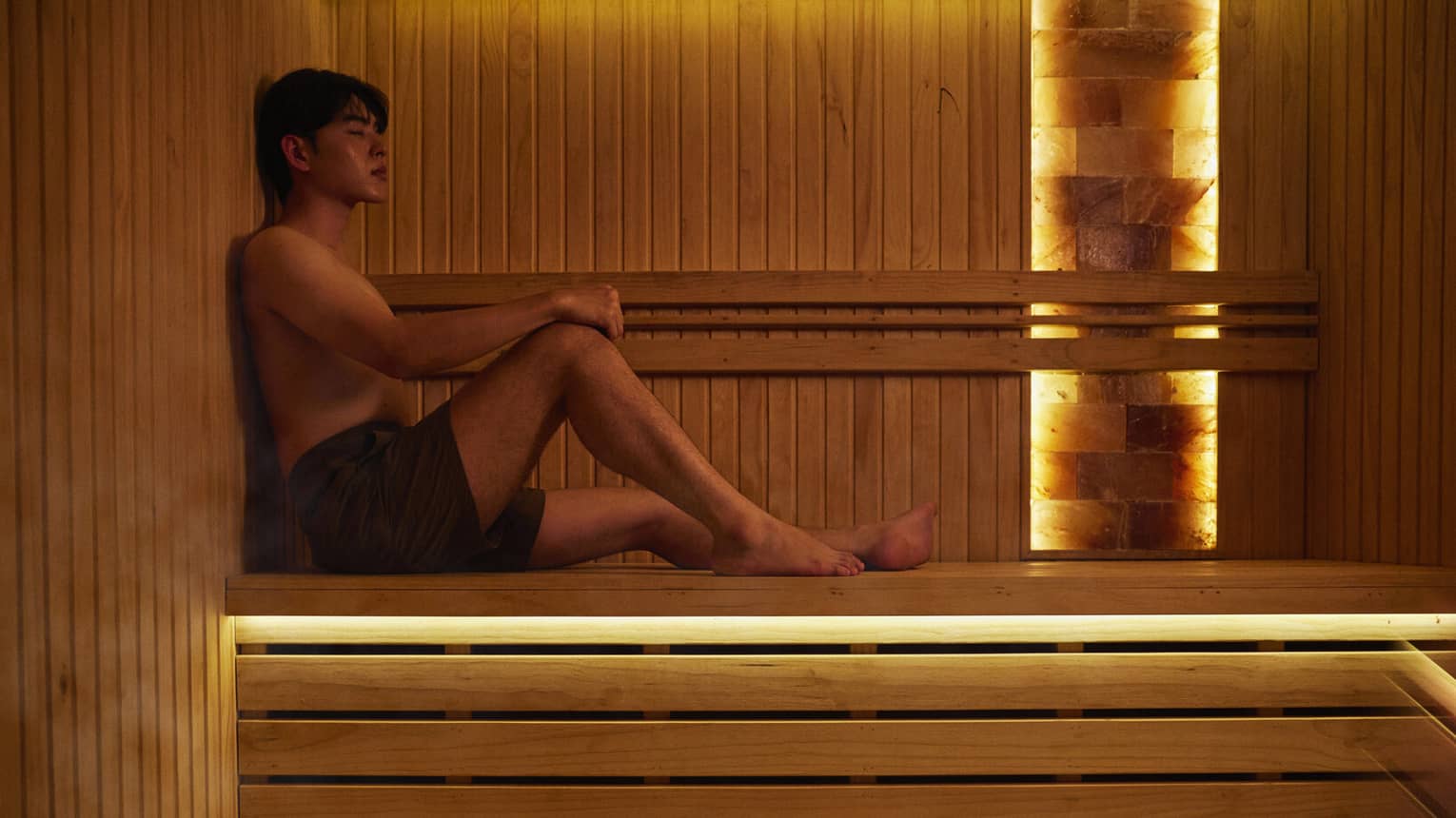 A man lounges in a sauna