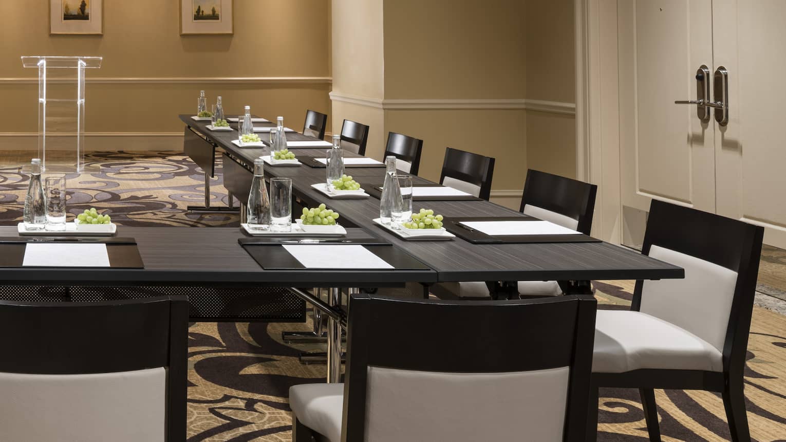 Meeting room with modular boardroom tables lines with white chairs 