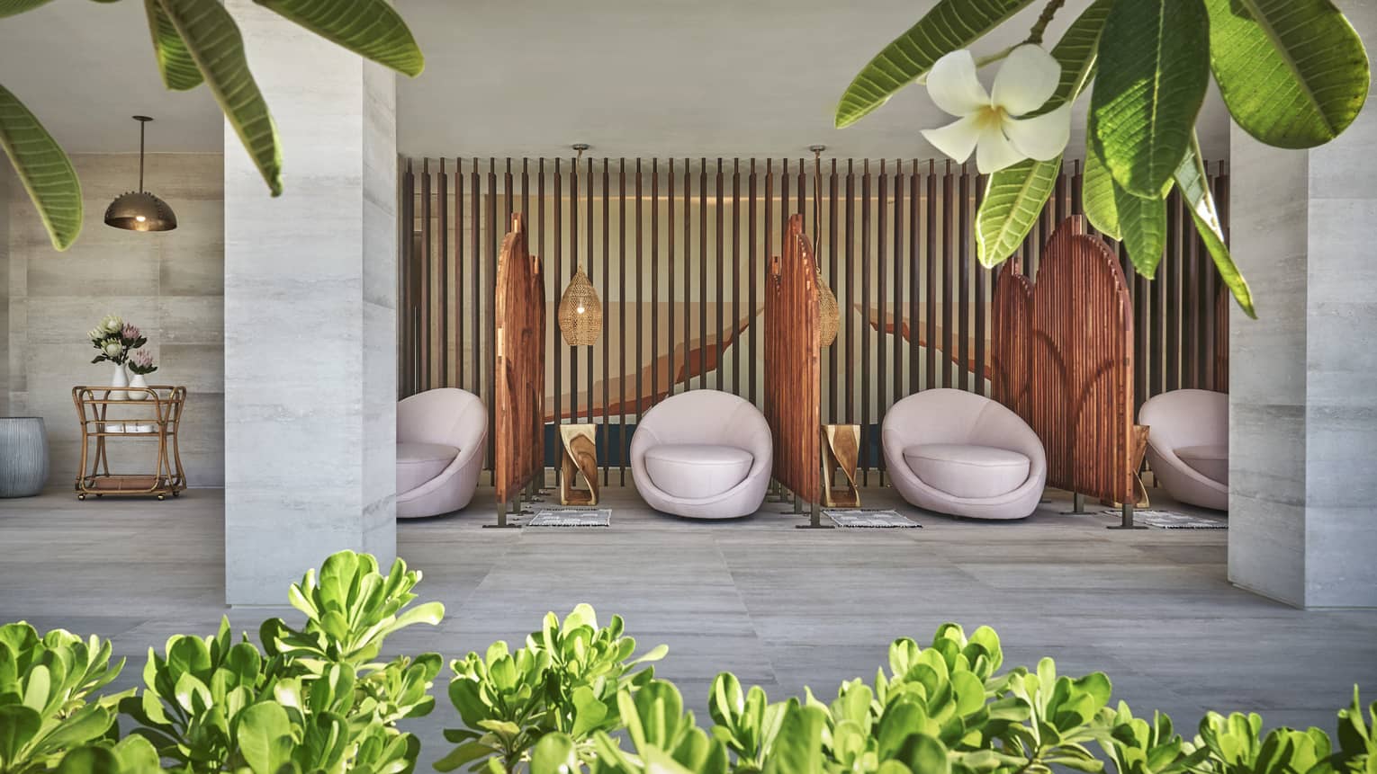White egg-shaped spa chairs are separated by rattan walls in the four seasons resort los cabos spa terrace