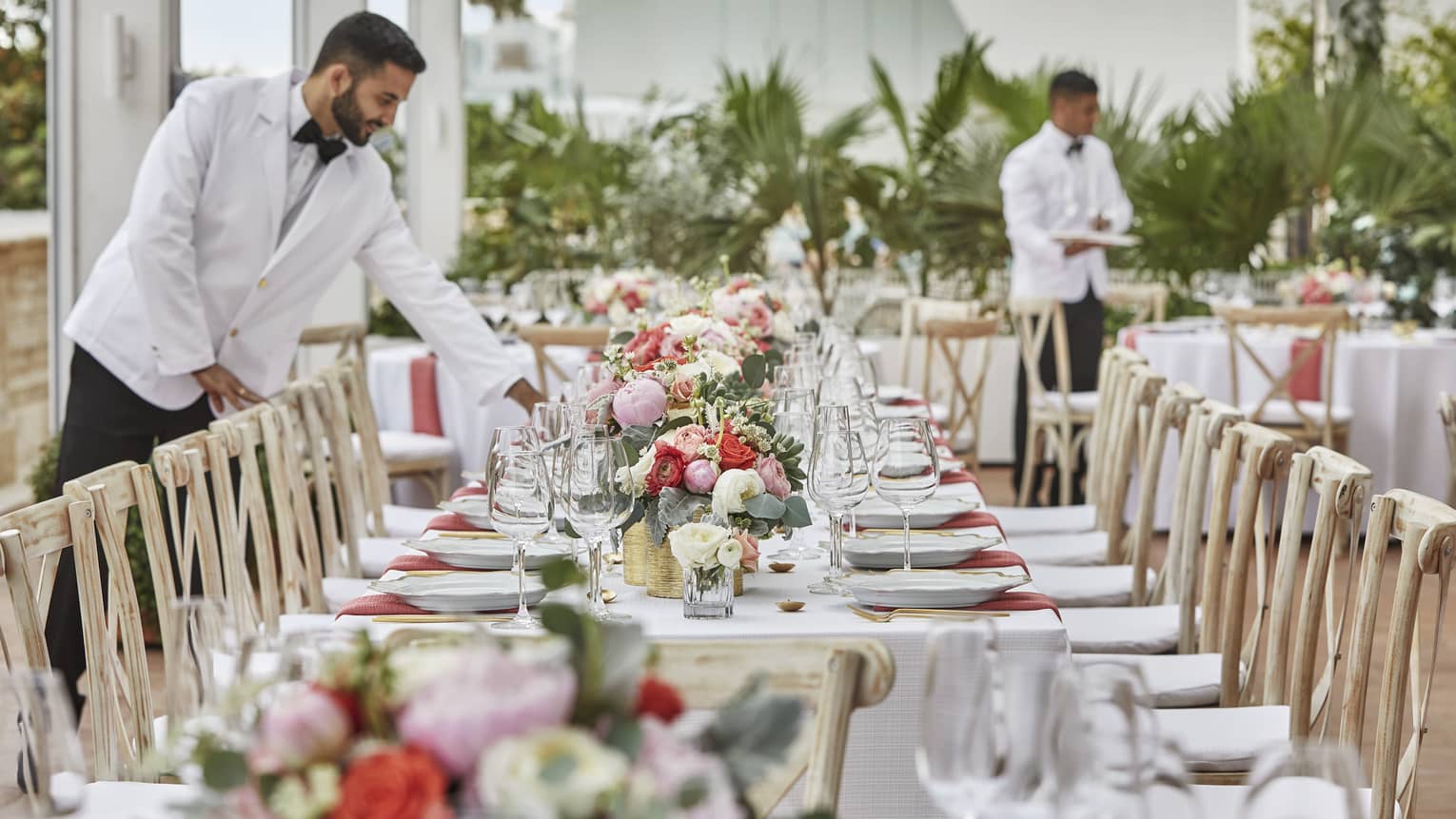 Elegant dining setup in an outdoor garden at Four Seasons Hotel with a beautifully set table, surrounded by lush greenery and flowers.