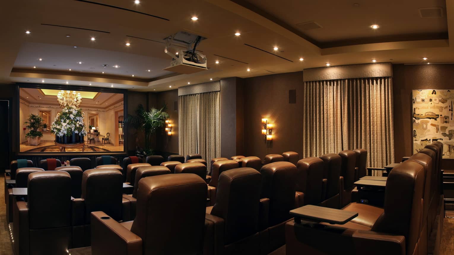 Rows of leather theatre chairs facing screen in movie screening room