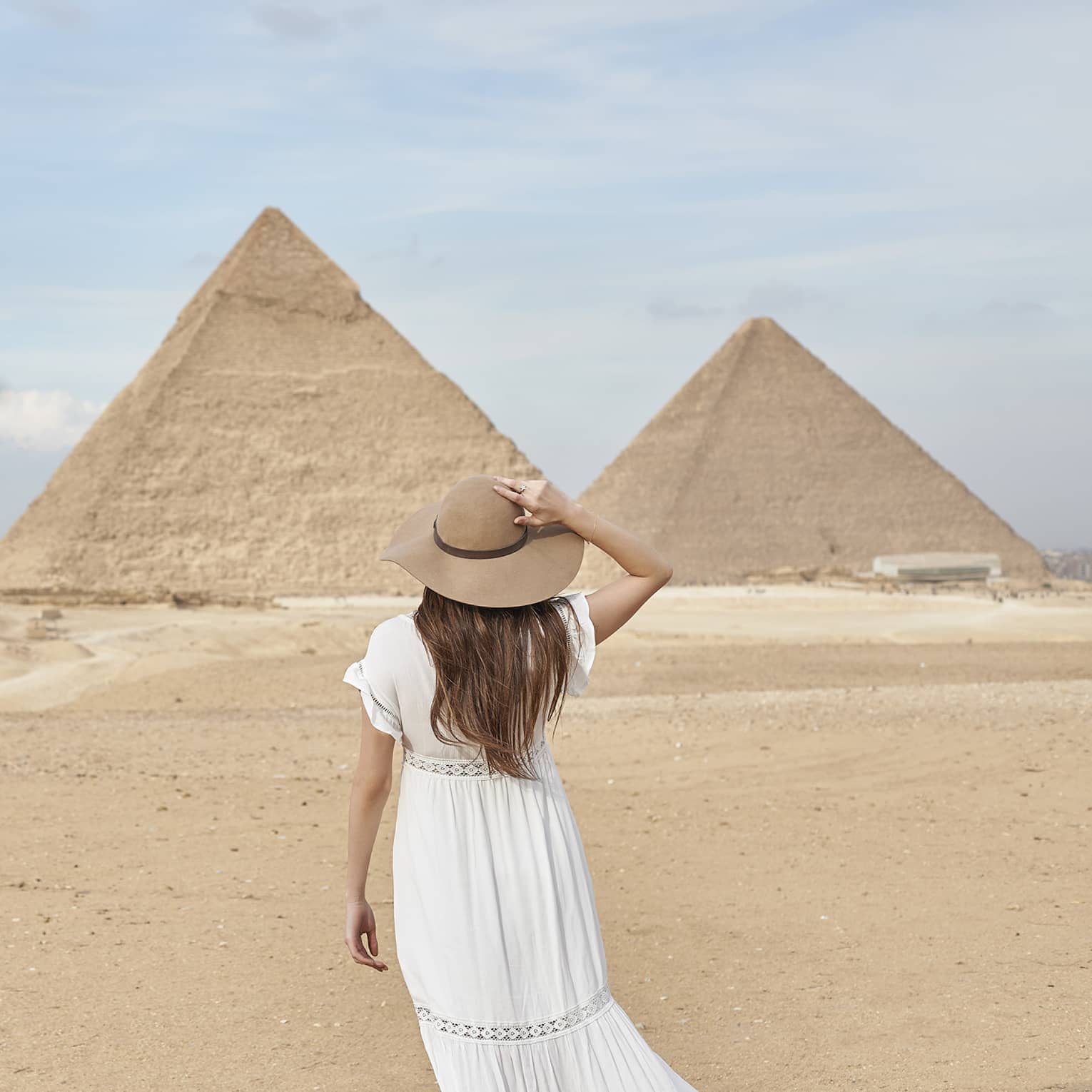A guest wearing a linen dress observing the Great Pyramids