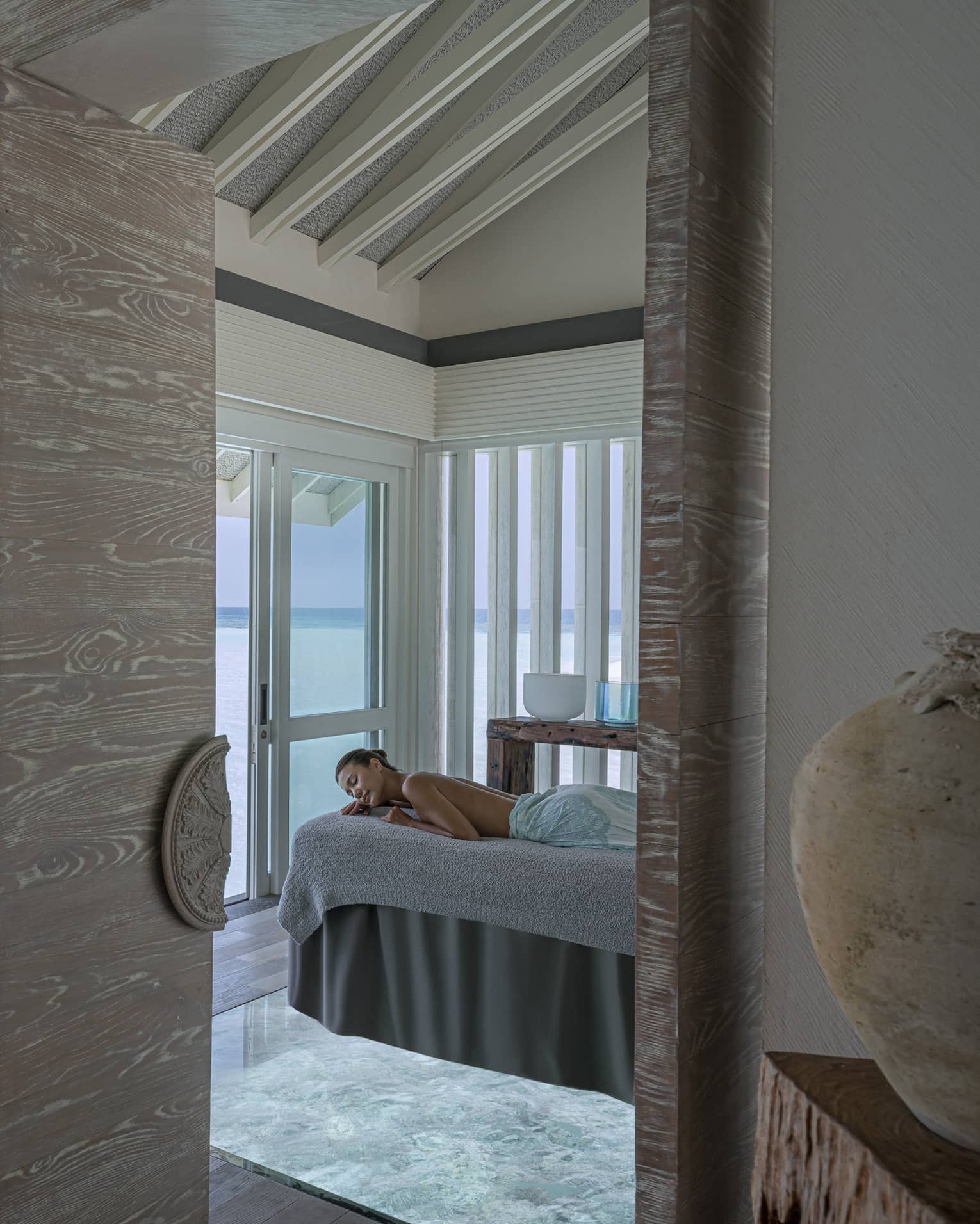 Woman on massage table overlooking the ocean at the Spa
