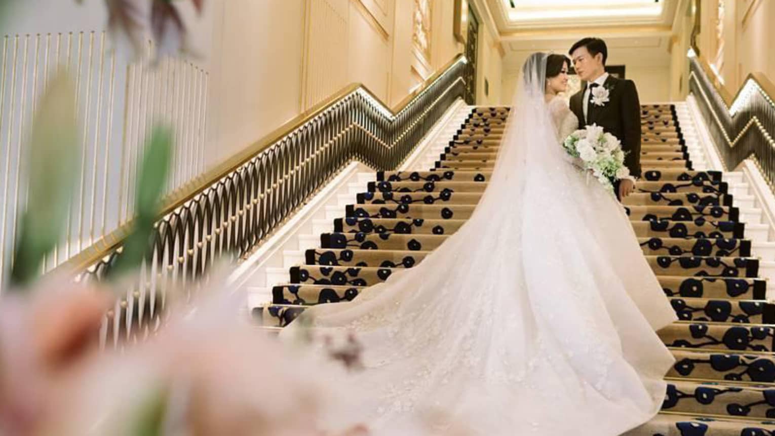 Wedding photo with groom, bride with long gown on staircase 