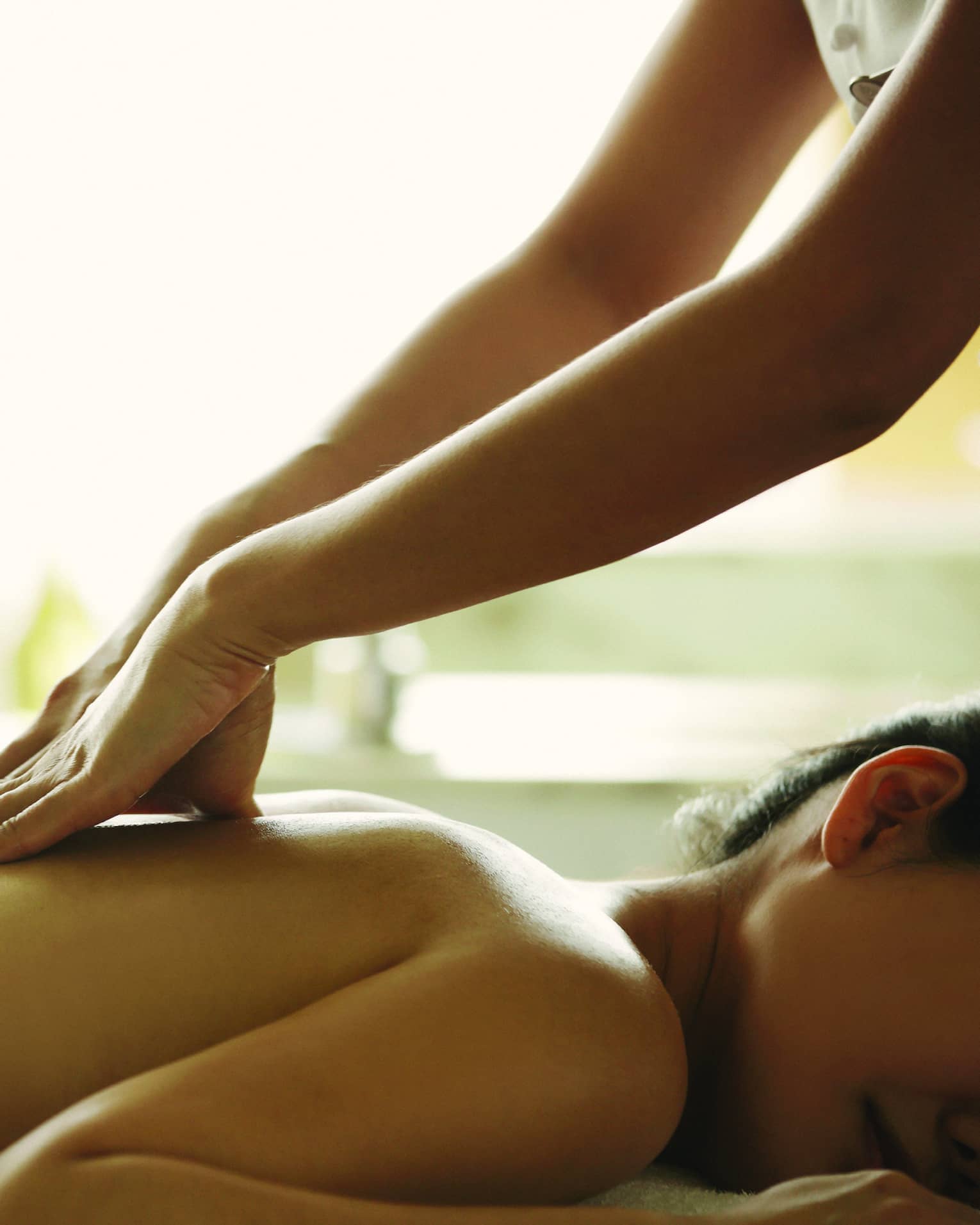 Close-up of a person receiving a relaxing back massage in a spa setting.
