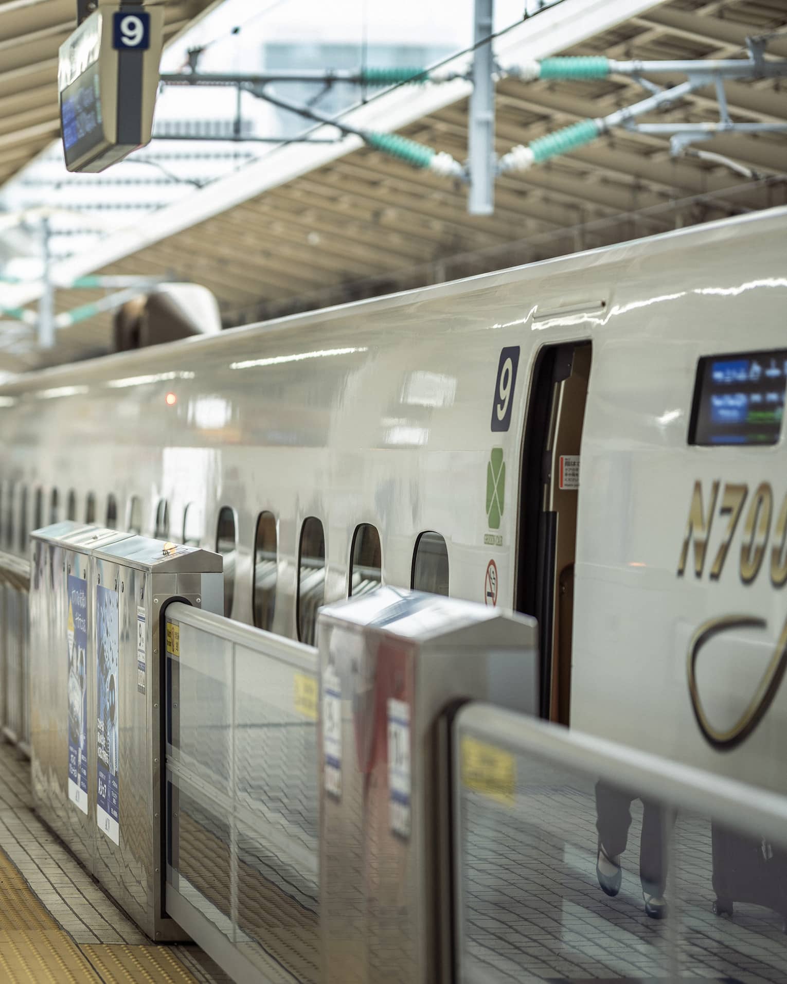 Train station greeter walks with female guest along the train platform