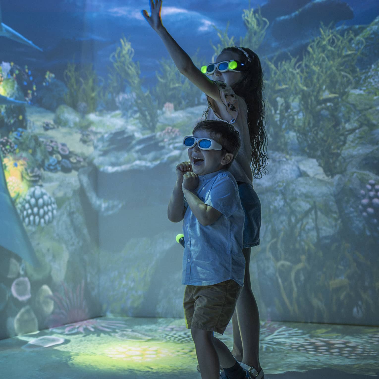 Young girl and boy wearing 3D glasses in the Hologram Room at the Marine Discovery Centre