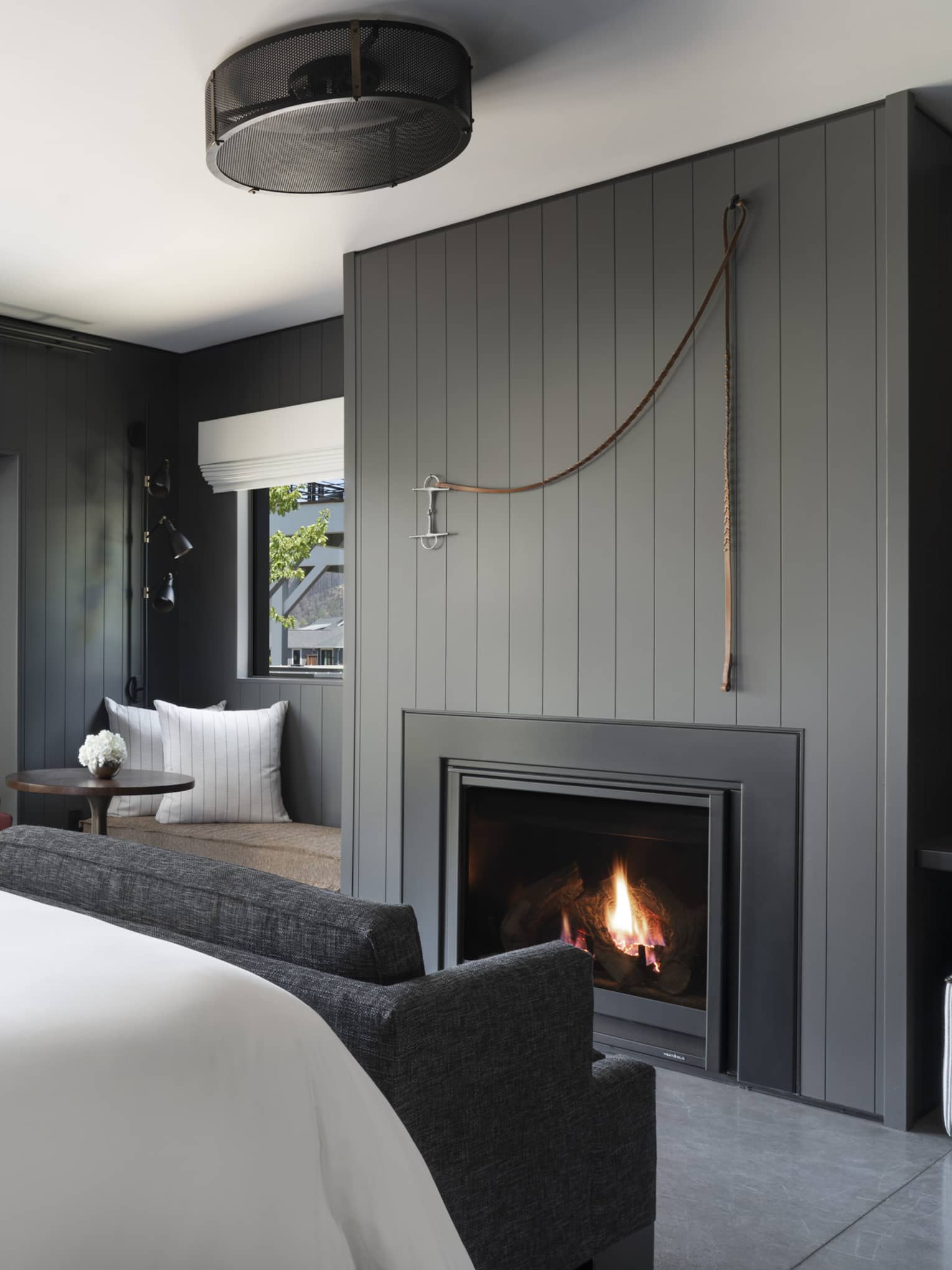 Luxury resort room with a king bed, cozy fireplace, vineyard view, seating area and outdoor patio facing rustic barn and mountains