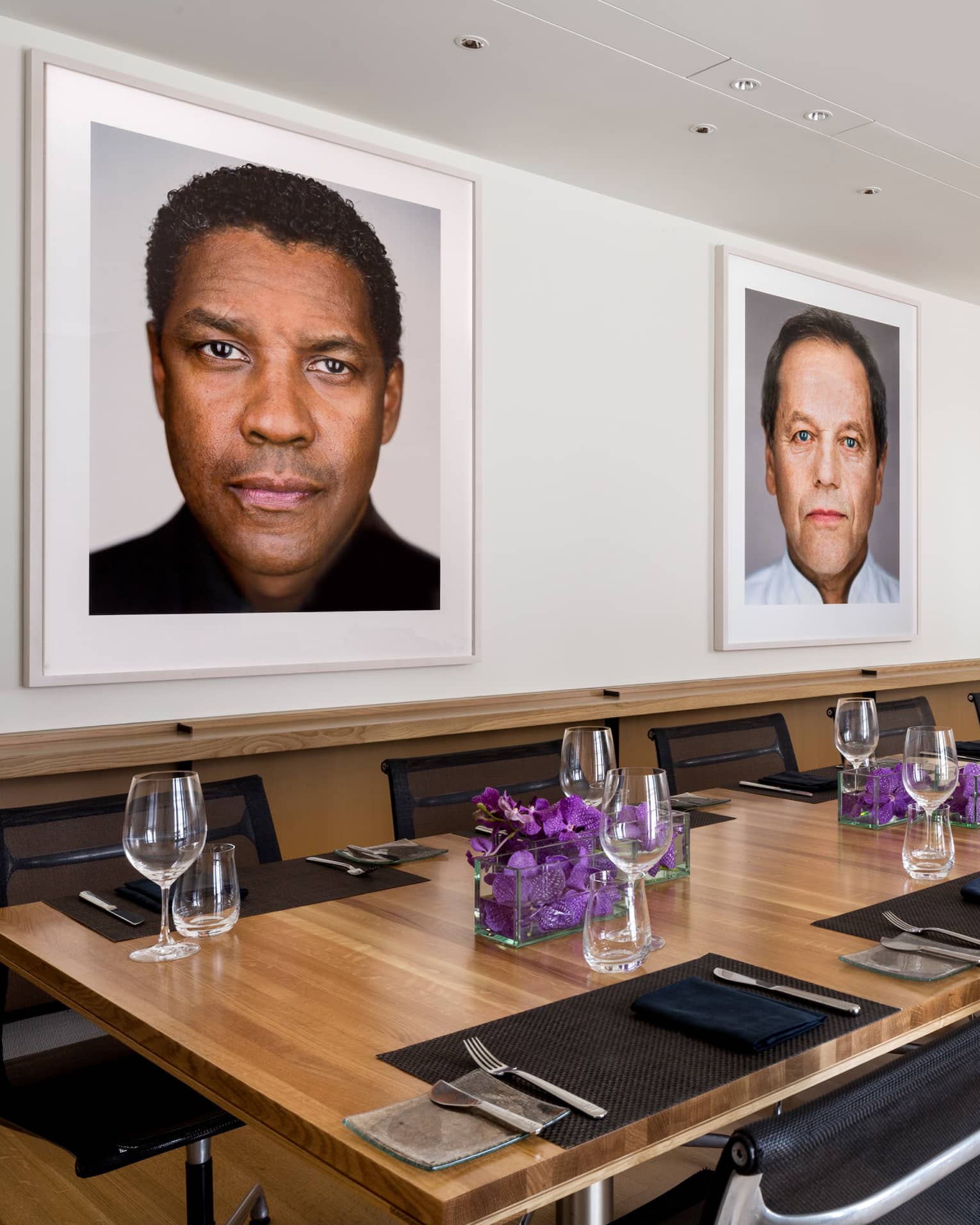 Cut Restaurant long wood dining table, purple flowers, framed portraits of Hollywood stars