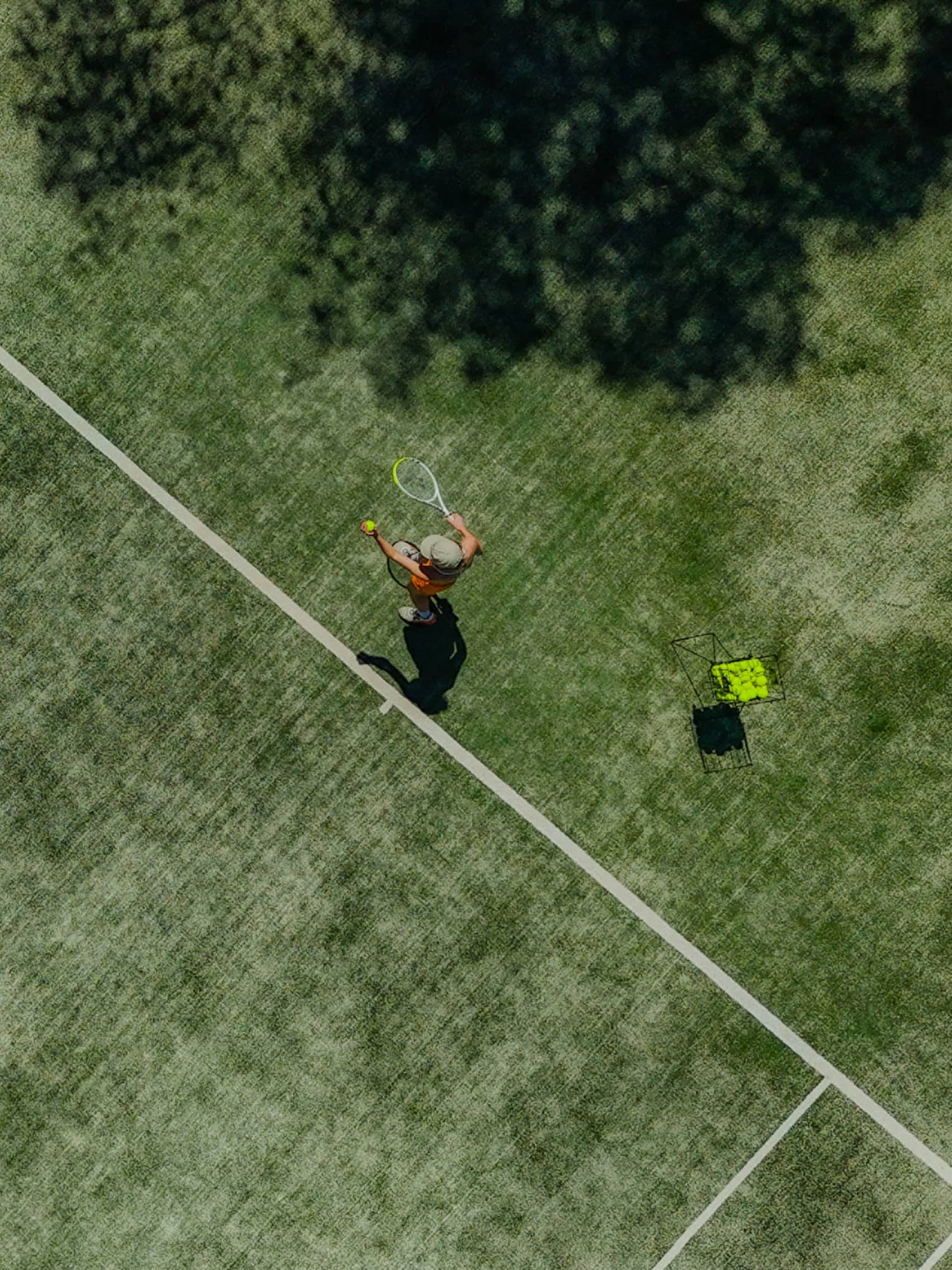 A tennis player in action on a green court on a sunny day