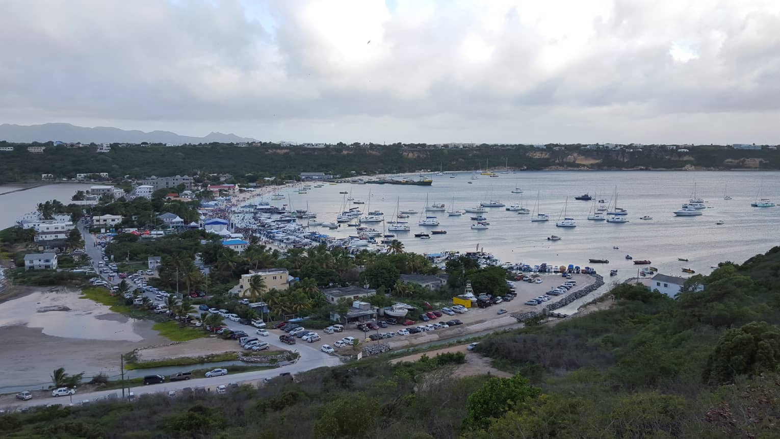 Aerial view of a busy harbour with sails and boats in Anguilla, cloudy skies