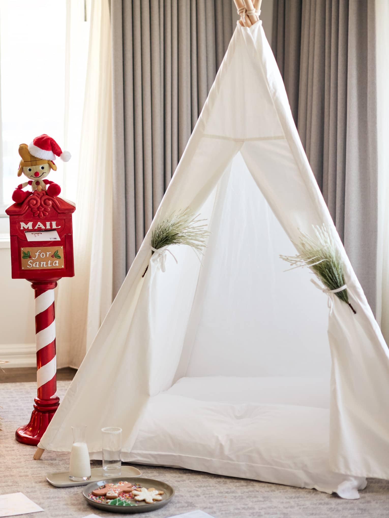 A tent next to a small Christmas tree.