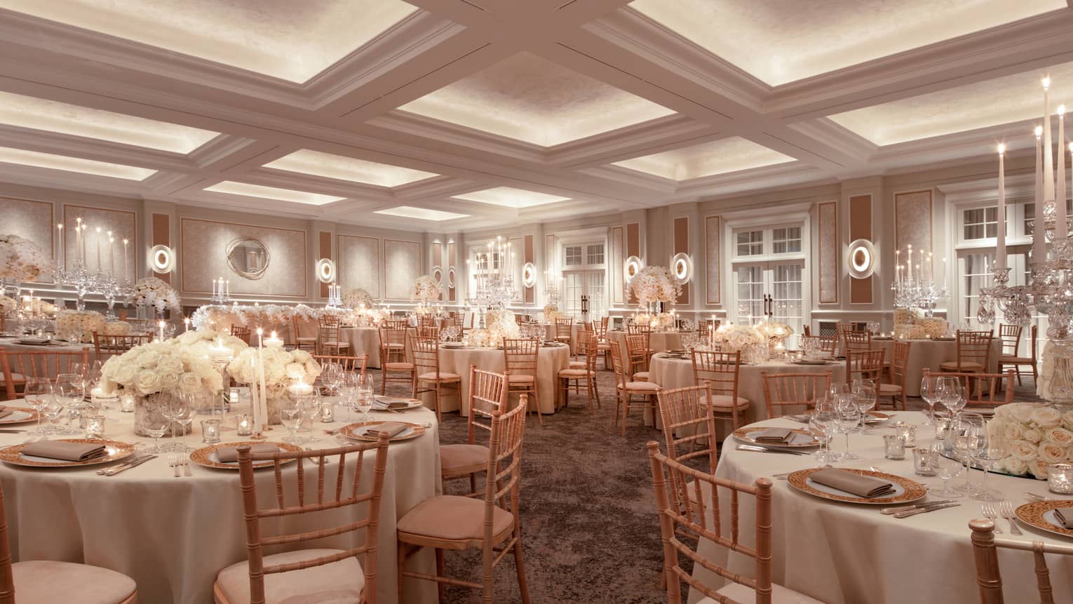 Wedding banquet tables with white linens, flowers in ballroom