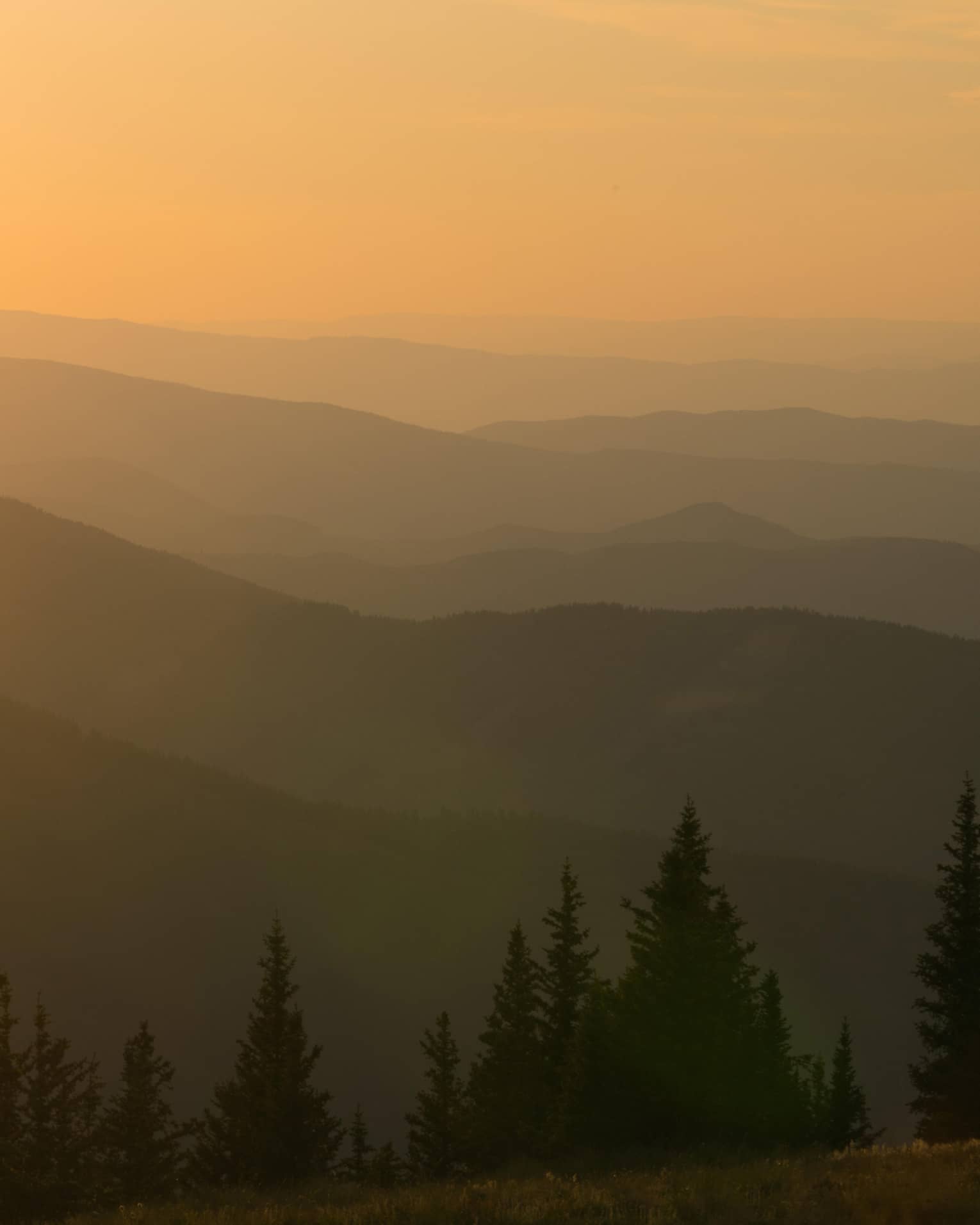 Helicopter at sunset flying over Aspen Mountain in the Elks Mountain range