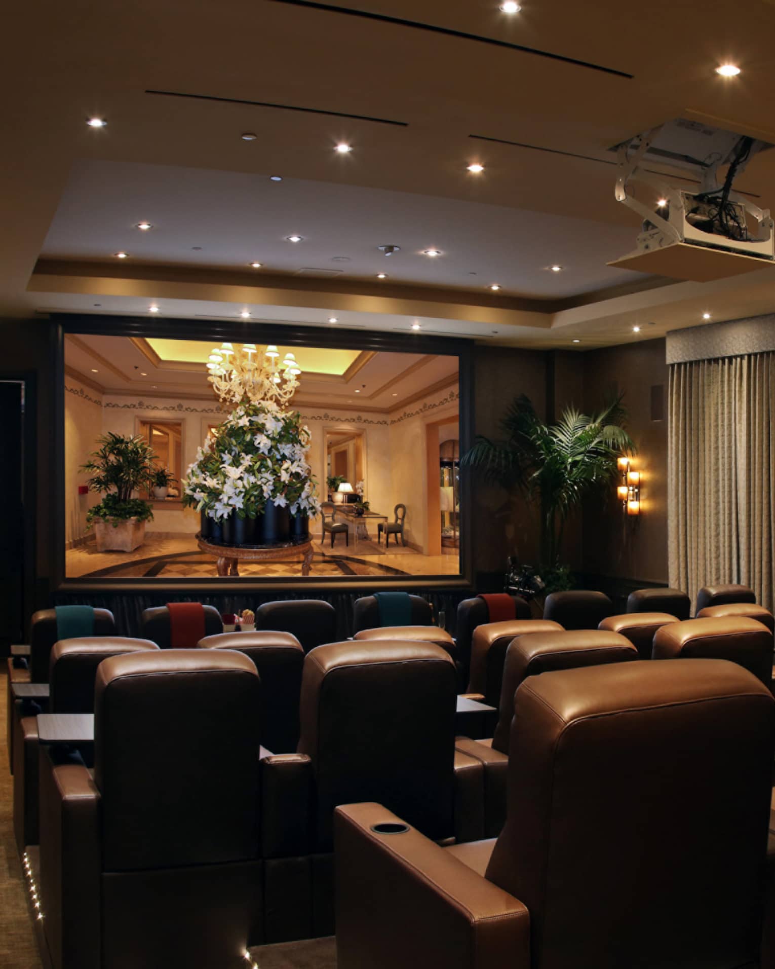 Rows of leather theatre chairs facing screen in movie screening room