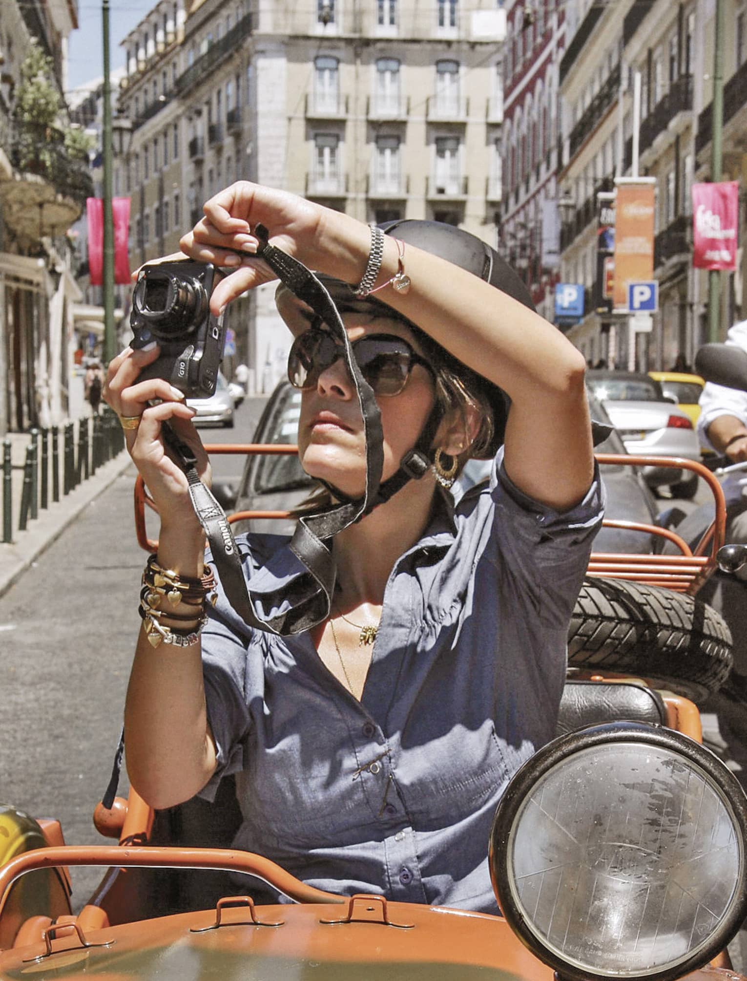 Woman sitting in Moto Side Car takes photos of streets