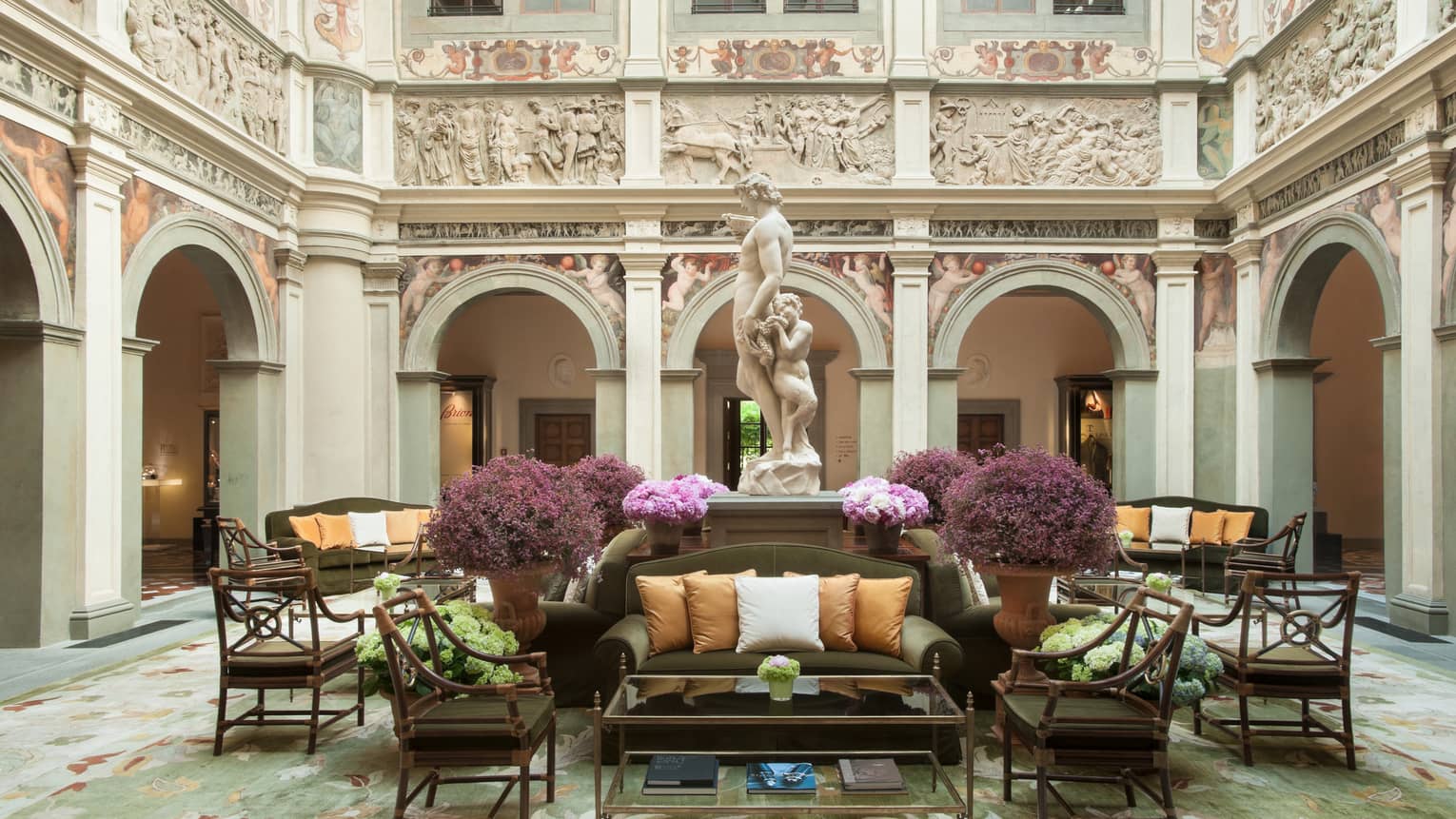 Hotel lobby sofas, chairs under statue, high ceilings and ornate walls