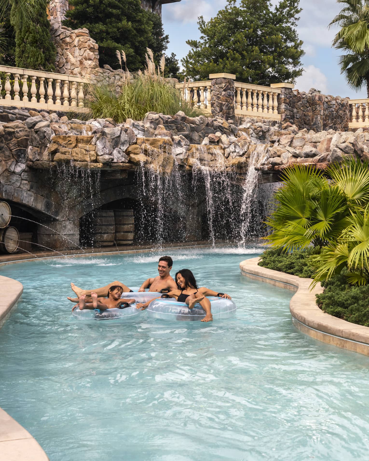 Two adults and a child ride in light-blue inner tubes along the Resort's outdoor lazy river
