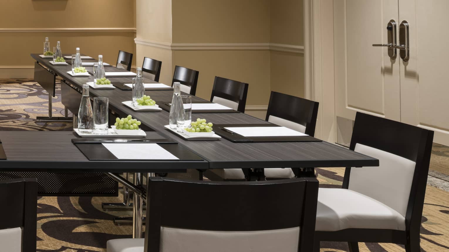 Meeting room with modular boardroom tables lines with white chairs 